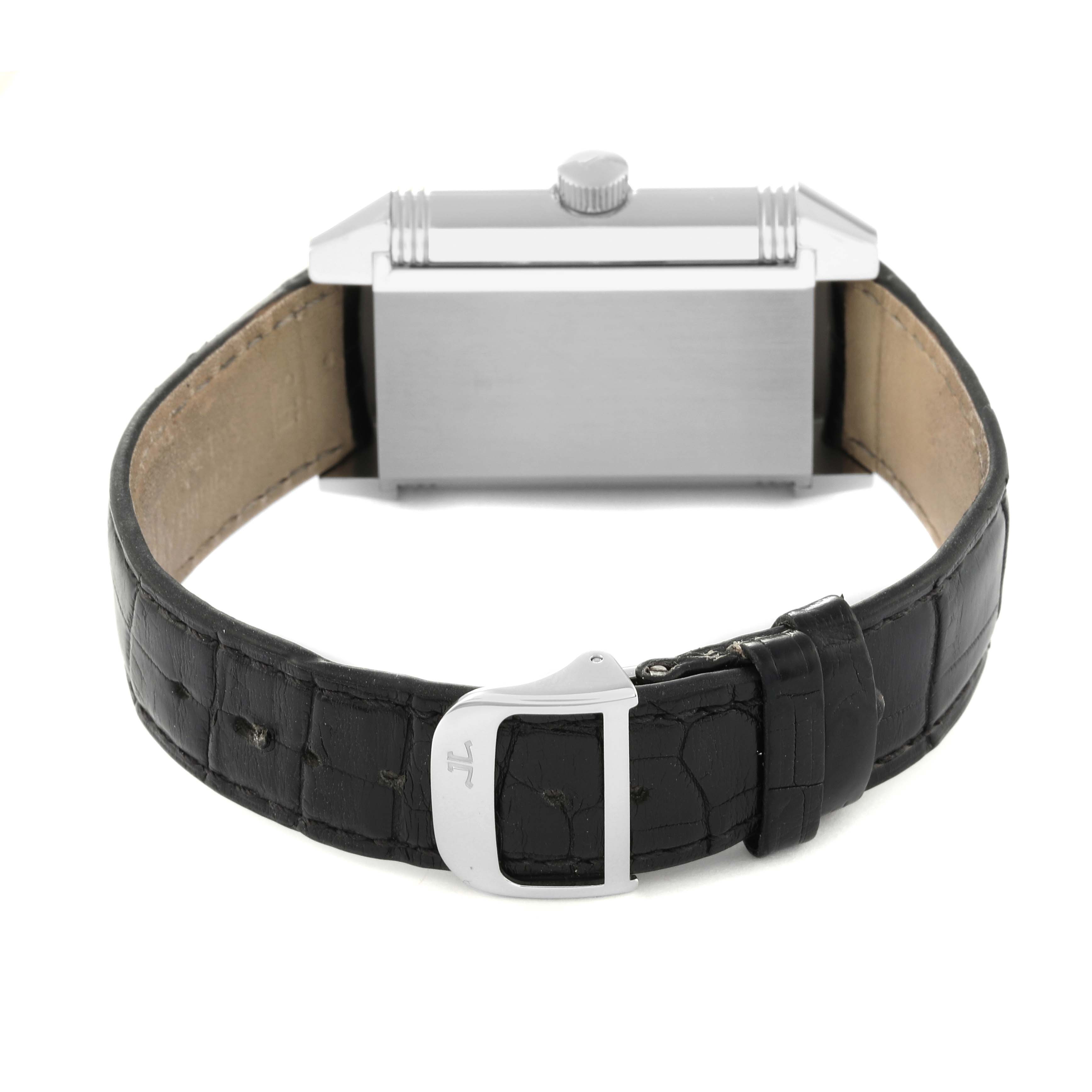 The image shows the back of a Jaeger-LeCoultre Reverso watch with a black leather strap and silver clasp.