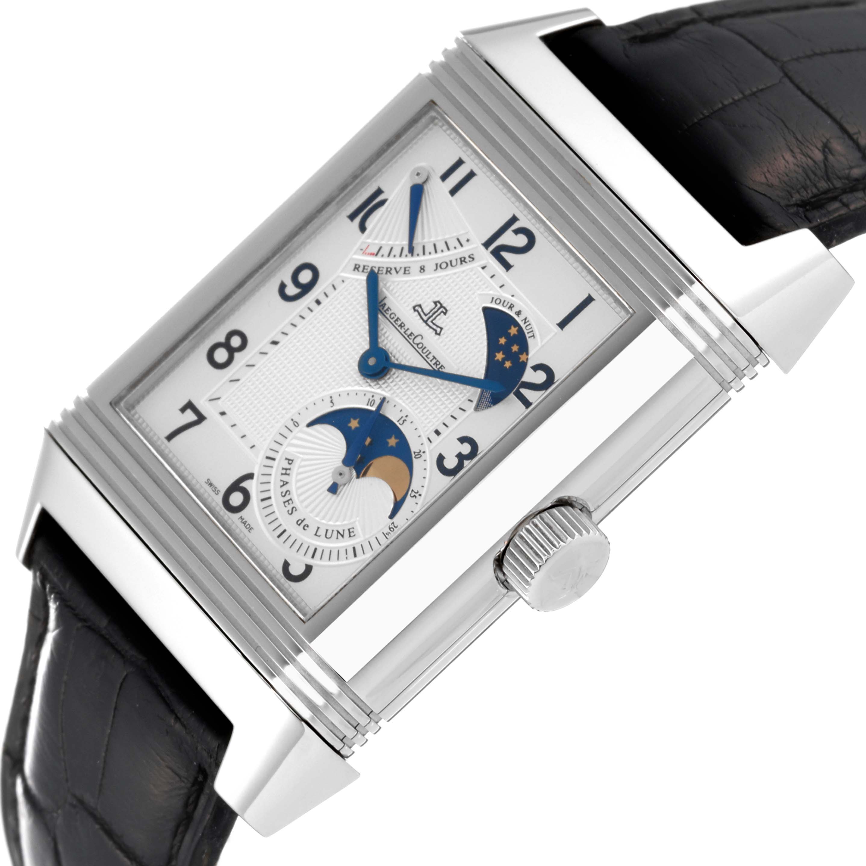 The image shows a close-up of the dial and part of the strap of a Jaeger-LeCoultre Reverso watch, featuring blue hands and moon phase.