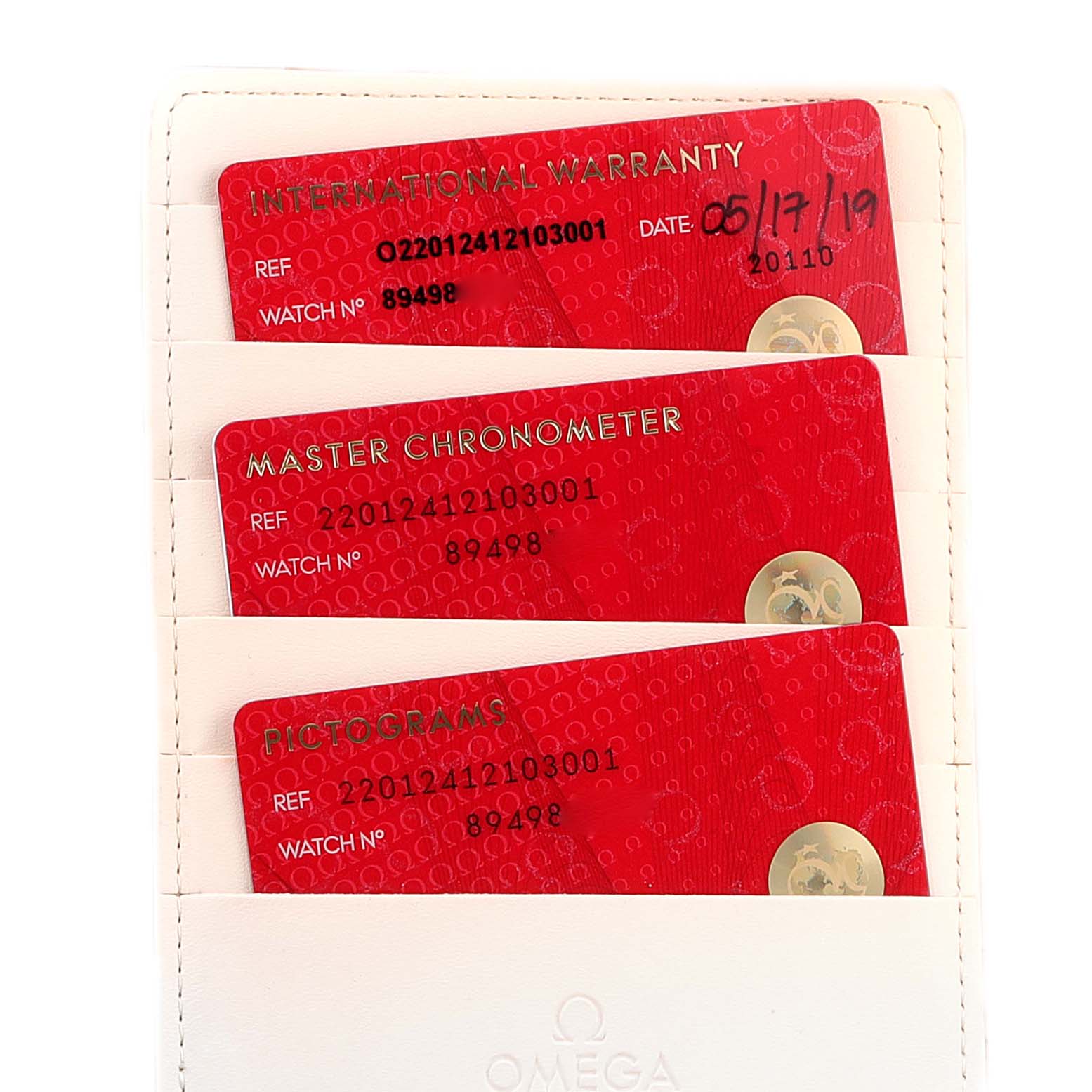 The image shows three red cards in an Omega Aqua Terra 220.12.41.21.03.001 Men's Stainless Steel Blue Dial 220.12.41.21.03.001 Men's Stainless Steel Blue Dial watch warranty and certification holder.