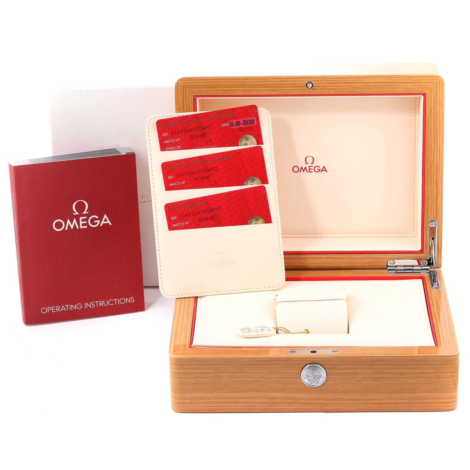 The image shows an open wooden Omega box for a Seamaster model, along with warranty cards and operating instructions.