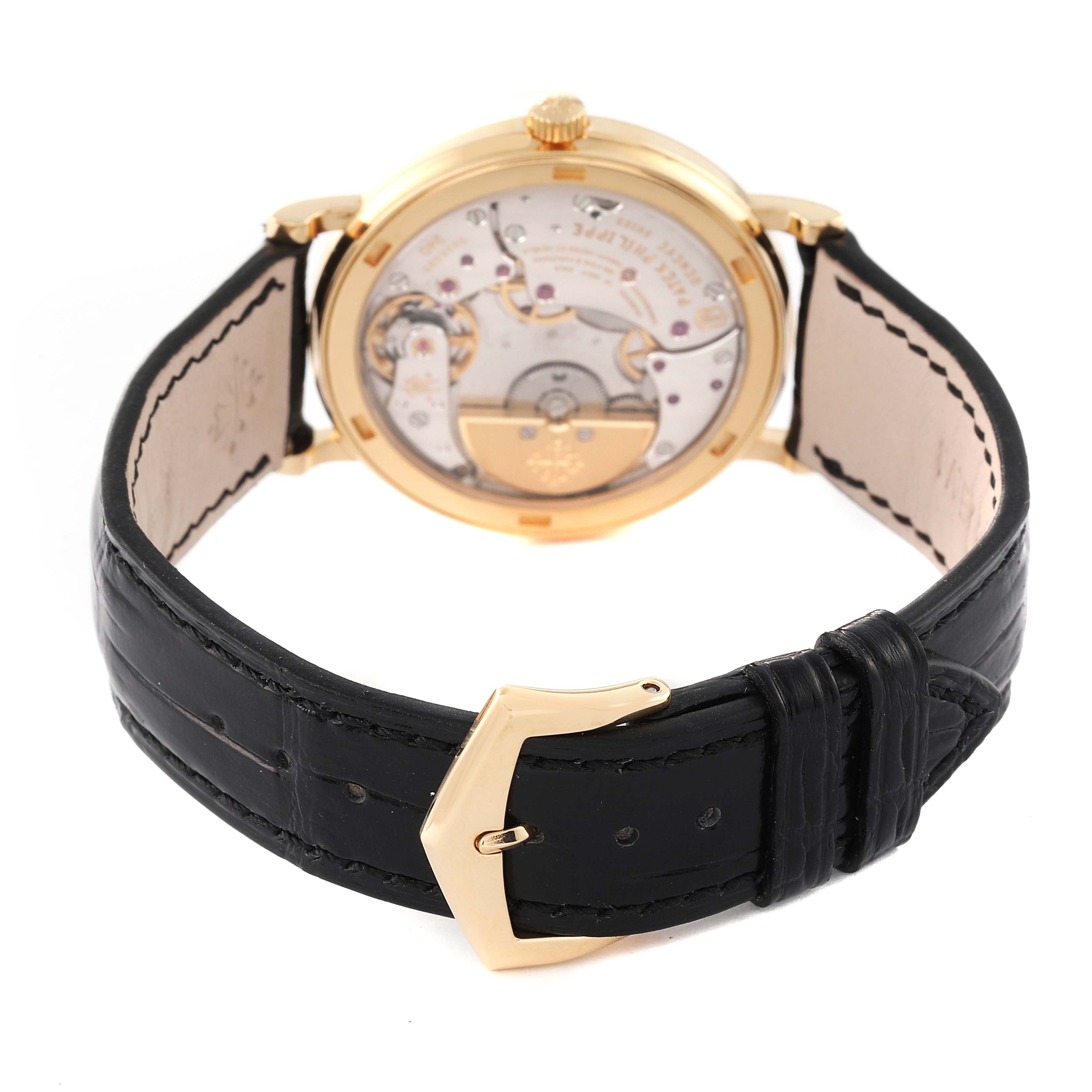 This image shows the back view of a Patek Philippe Calatrava 5120J Men's Yellow Gold White Dial 5120J Men's Yellow Gold White Dial watch, highlighting its mechanical movement and black leather strap.