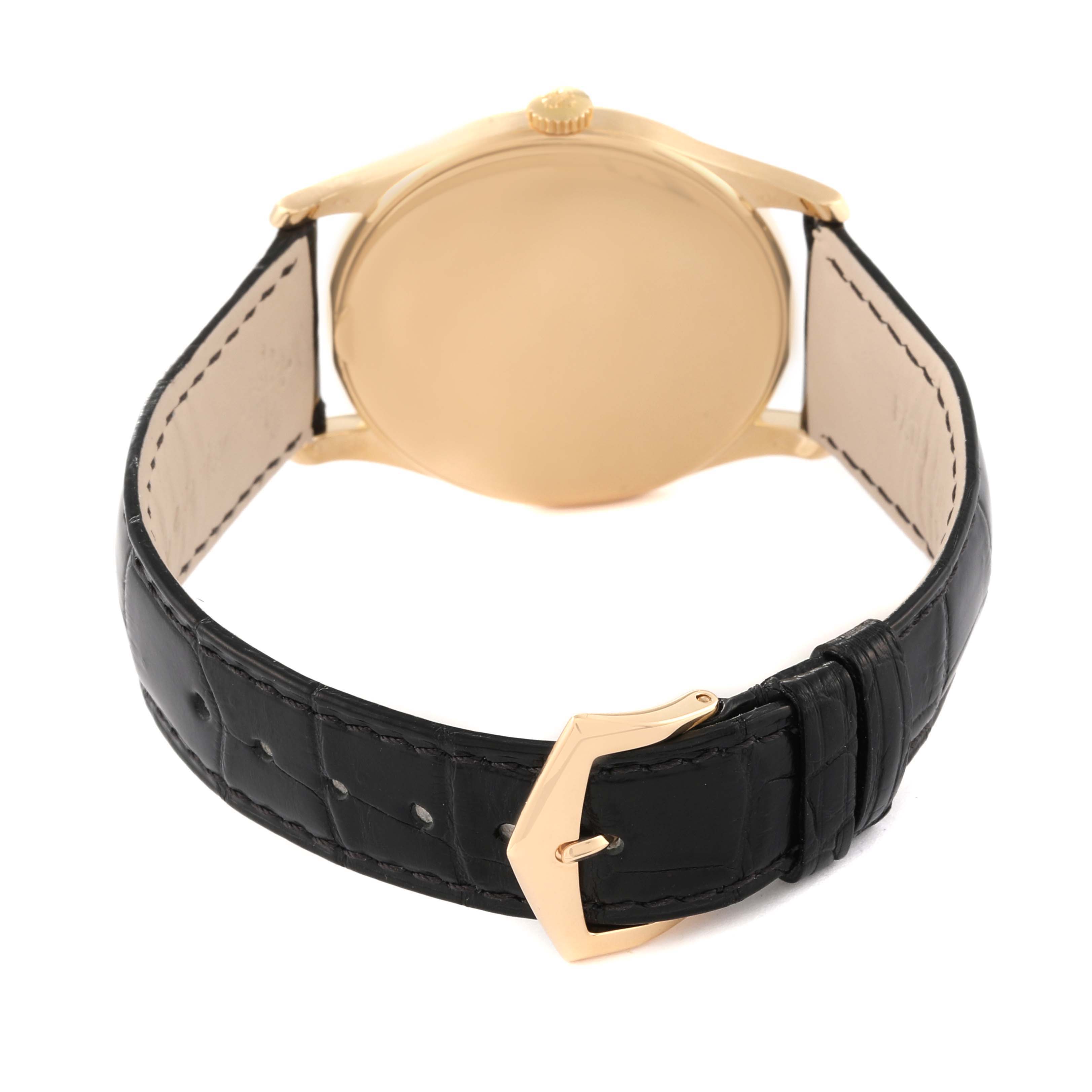 The image shows the back view of a Patek Philippe Calatrava 5196J Men's Yellow Gold Silver Dial 5196J Men's Yellow Gold Silver Dial watch, highlighting its case, crown, and leather strap with a buckle.