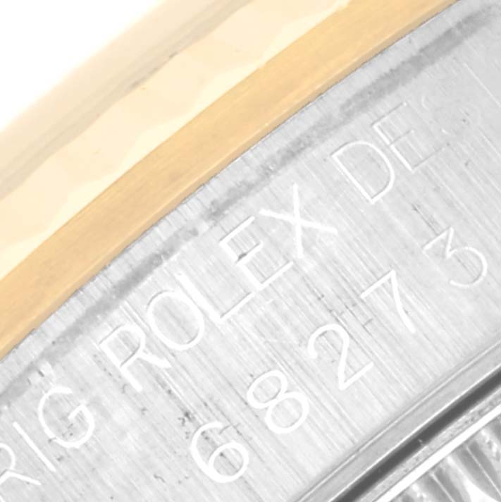 This image shows a close-up of the engraved serial number and "ROLEX" text on a Mid-Size Rolex watch.