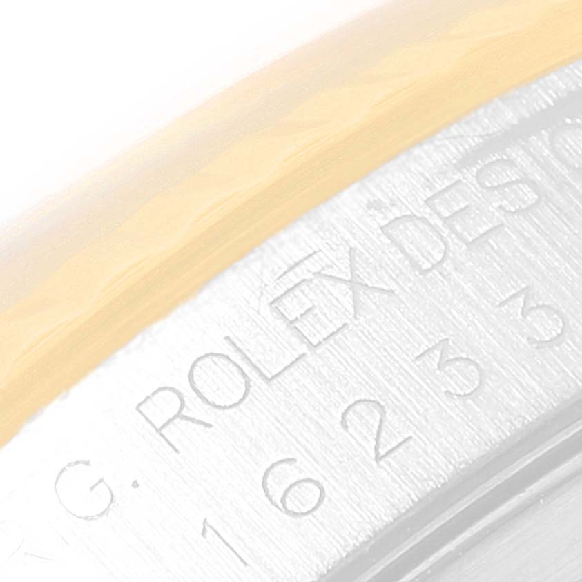 Close-up of the edge of a Rolex Datejust 16233 Men's Steel and Gold (two tone) Grey Dial 16233 Men's Steel and Gold (two tone) Grey Dial, displaying the engraved branding and part of the bezel.