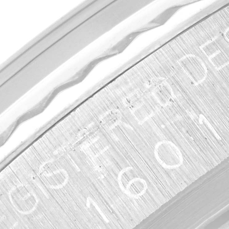 This close-up image of a Rolex Vintage Collection 1601 Men's Stainless Steel Silver Dial 1601 Men's Stainless Steel Silver Dial watch showcases the engraved serial number and part of the bezel.