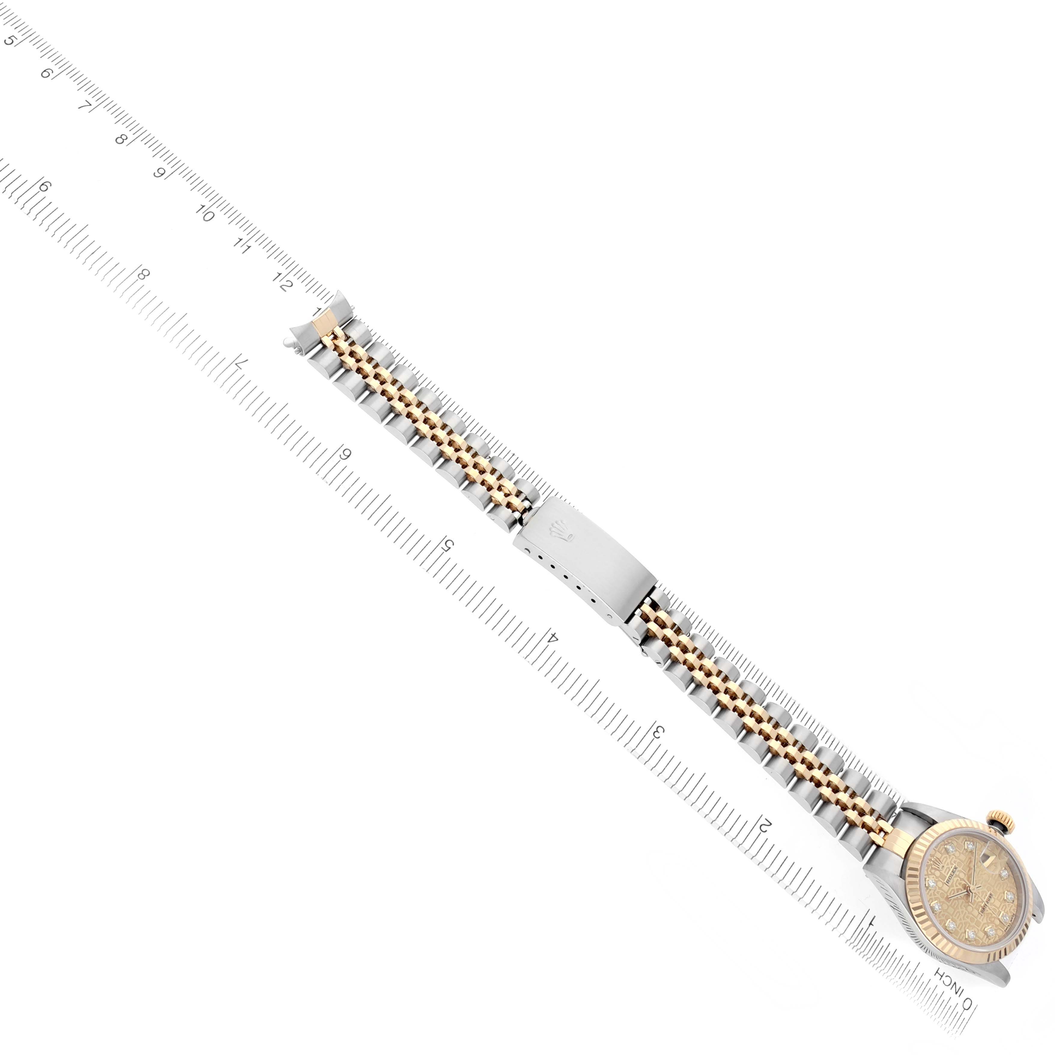 The Rolex Datejust 69173 Women's Steel and Gold (two tone) Champagne Dial 69173 Women's Steel and Gold (two tone) Champagne Dial watch is shown from a top angle, highlighting its face and two-tone bracelet aligned with a ruler.