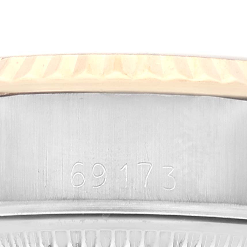 This image shows a close-up of the side of the Rolex Datejust 69173 Women's Steel and Gold (two tone) White Dial 69173 Women's Steel and Gold (two tone) White Dial watch, highlighting the bezel and part of the case with engraved numbers.