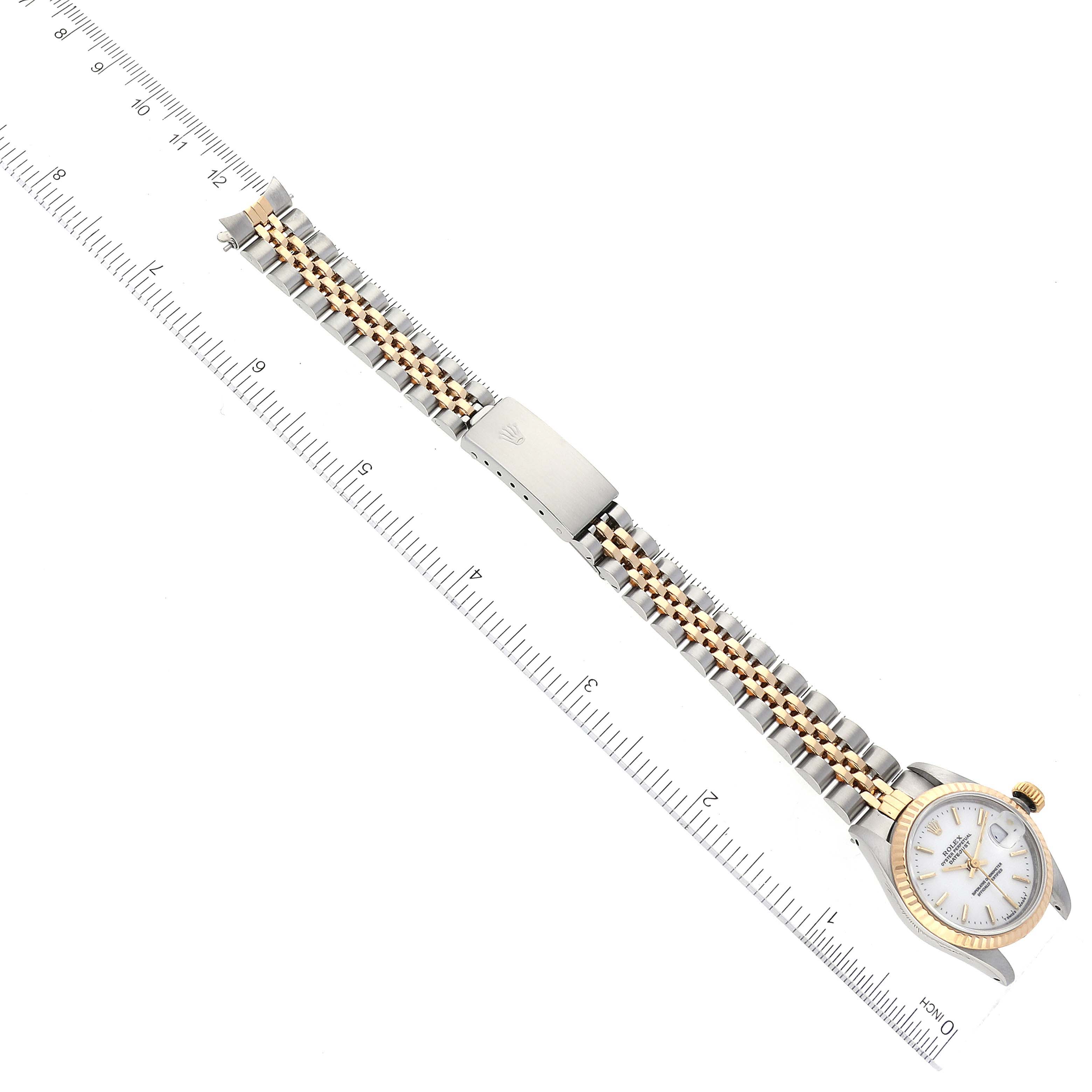 This image shows a Rolex Datejust 69173 Women's Steel and Gold (two tone) White Dial 69173 Women's Steel and Gold (two tone) White Dial watch laid flat next to a ruler, displaying the watch face and metal strap in full view from a top-down angle.