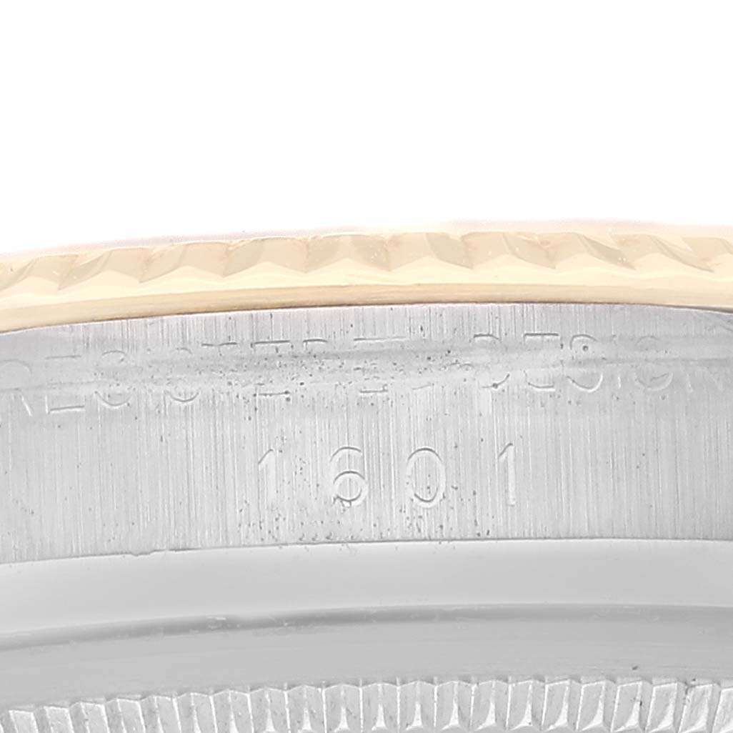 This close-up shows the Rolex Datejust 1601 Men's Steel and Gold (two tone) Champagne Dial 1601 Men's Steel and Gold (two tone) Champagne Dial model's bezel and part of the case with engraving.