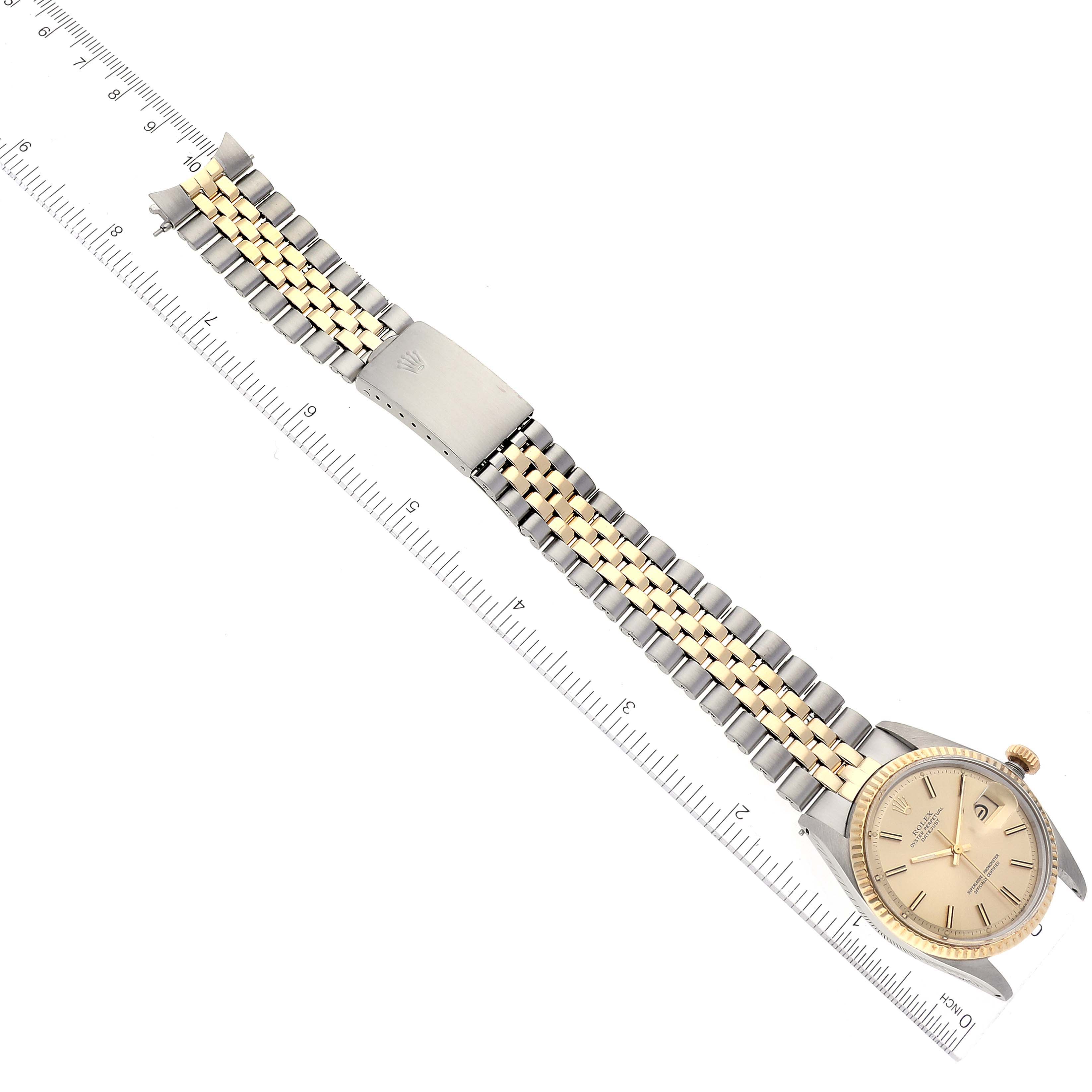 The image shows a Rolex Datejust 1601 Men's Steel and Gold (two tone) Champagne Dial 1601 Men's Steel and Gold (two tone) Champagne Dial model watch lying flat with its bracelet fully extended next to a ruler.