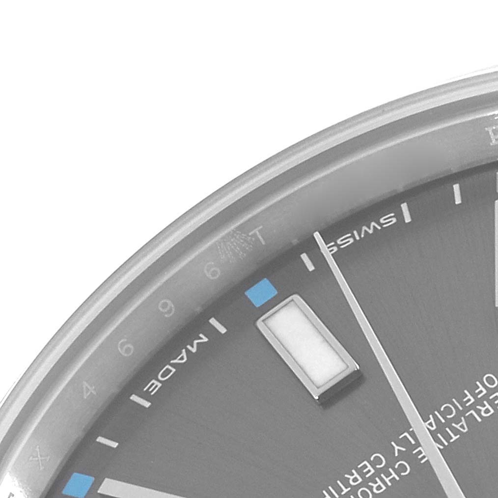 This image shows a close-up angle of the dial, markers, and a portion of the casing of a Rolex Oyster Perpetual 114300 Men's Stainless Steel Grey Dial 114300 Men's Stainless Steel Grey Dial watch.