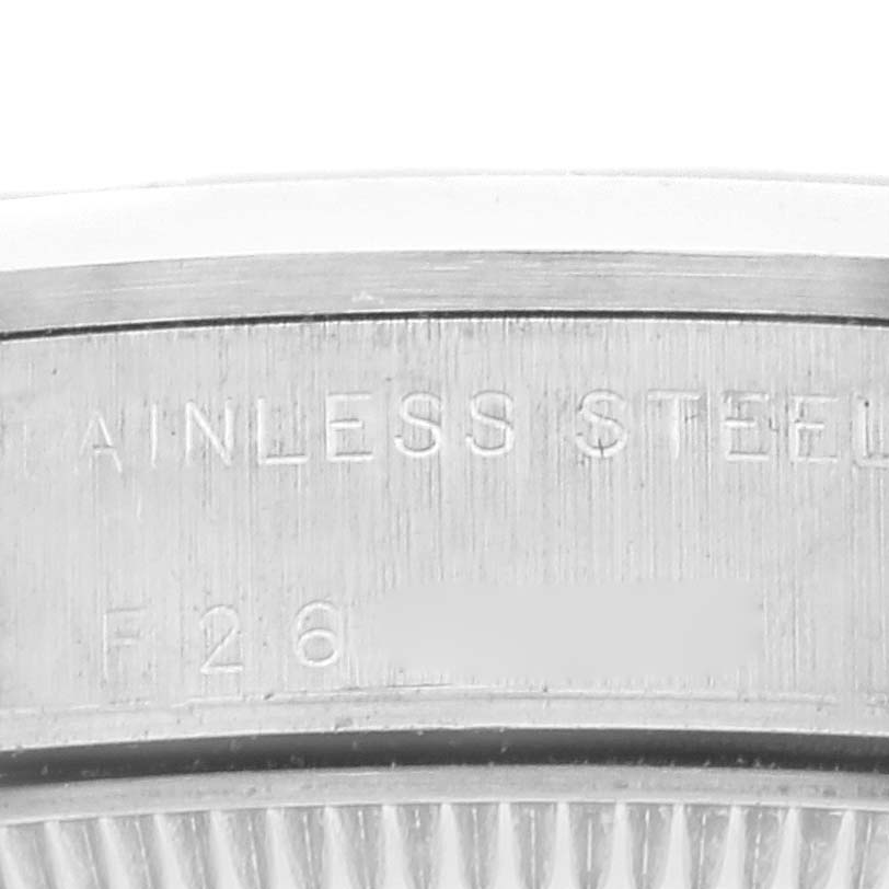 This image shows a close-up of the engraving on the case back of a Mid-Size Rolex watch, highlighting the stainless steel marking.