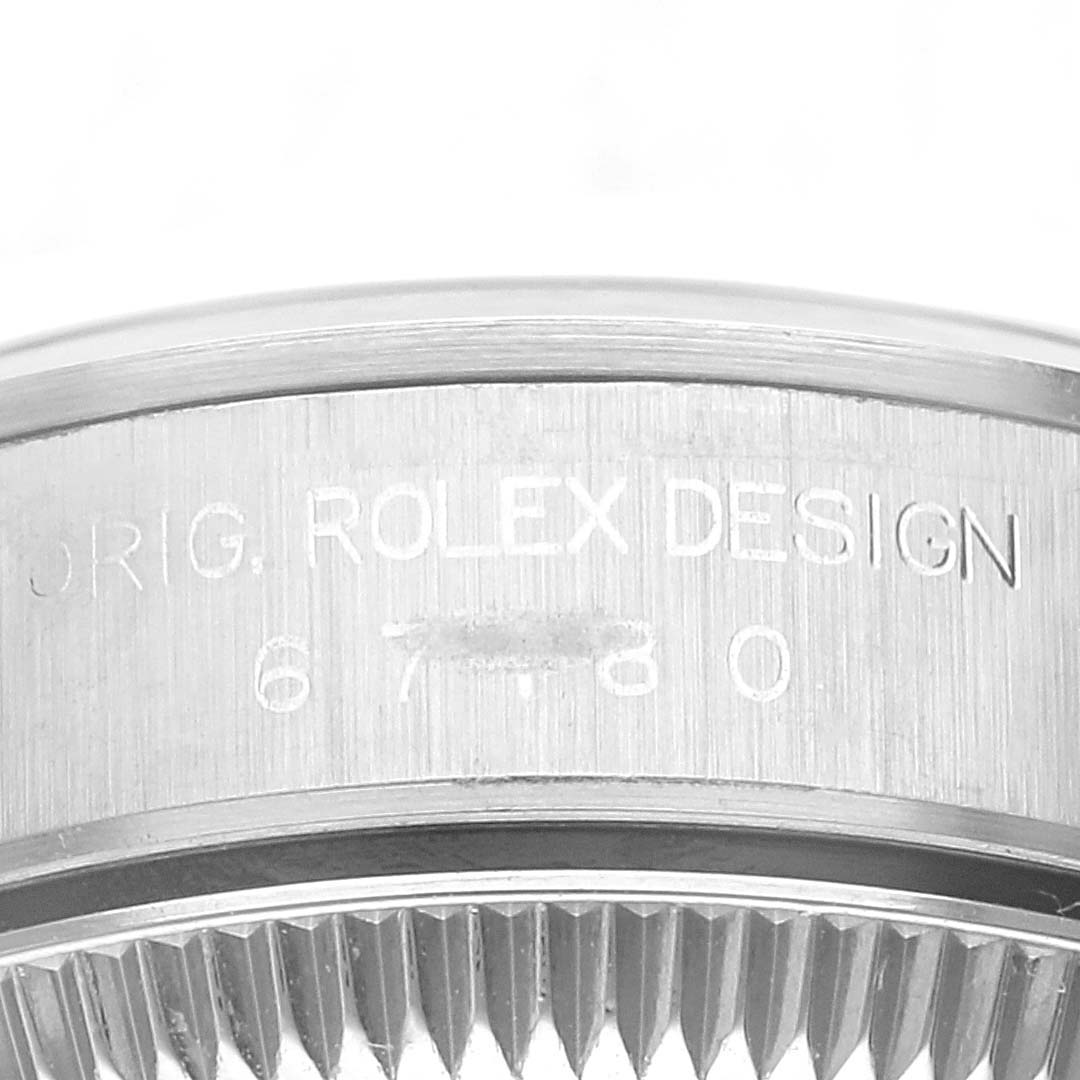 This is a close-up view of the case side of a Rolex Oyster Perpetual 67180 Women's Stainless Steel Blue Dial 67180 Women's Stainless Steel Blue Dial watch, showing the engraved model number and "ROLEX DESIGN".
