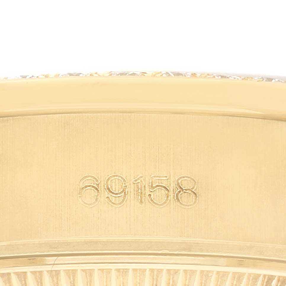 This close-up angle of the Rolex President 69158 Women
s Yellow Gold Champagne Dial 69158 Women
s Yellow Gold Champagne Dial model shows the engraved serial number on its gold casing.