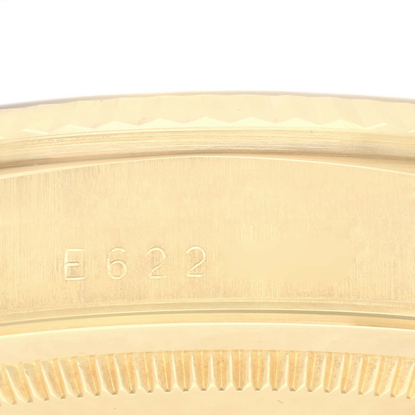This image shows a close-up of the side of a Rolex President 18238 Men
s Yellow Gold Champagne Dial 18238 Men
s Yellow Gold Champagne Dial watch case, featuring the engraved serial number E622.