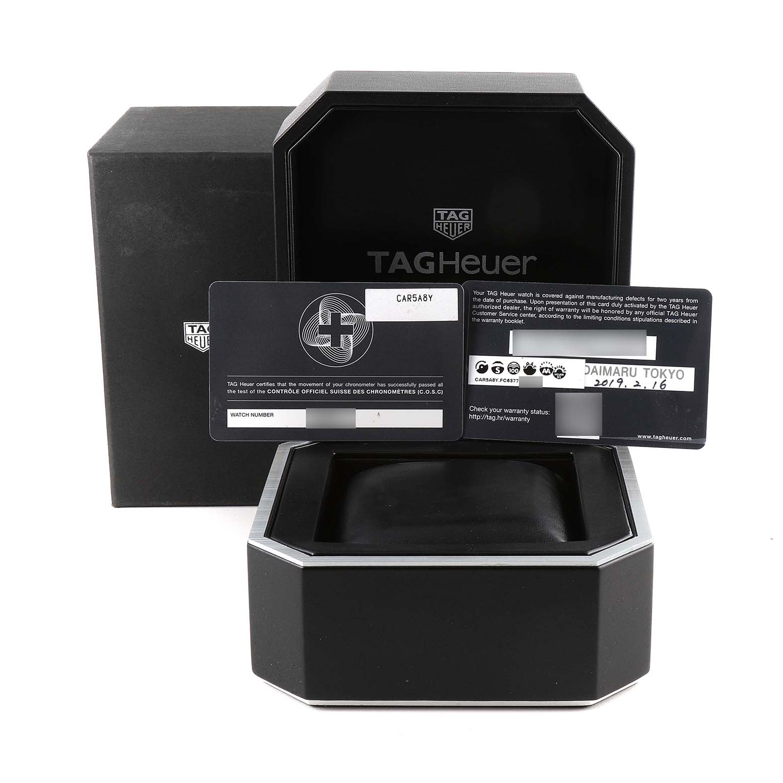 The image shows the packaging and warranty cards for a Tag Heuer Carrera CAR5A8Y.FC6377 Men's Titanium Black Dial CAR5A8Y.FC6377 Men's Titanium Black Dial watch, displayed from the front angle.