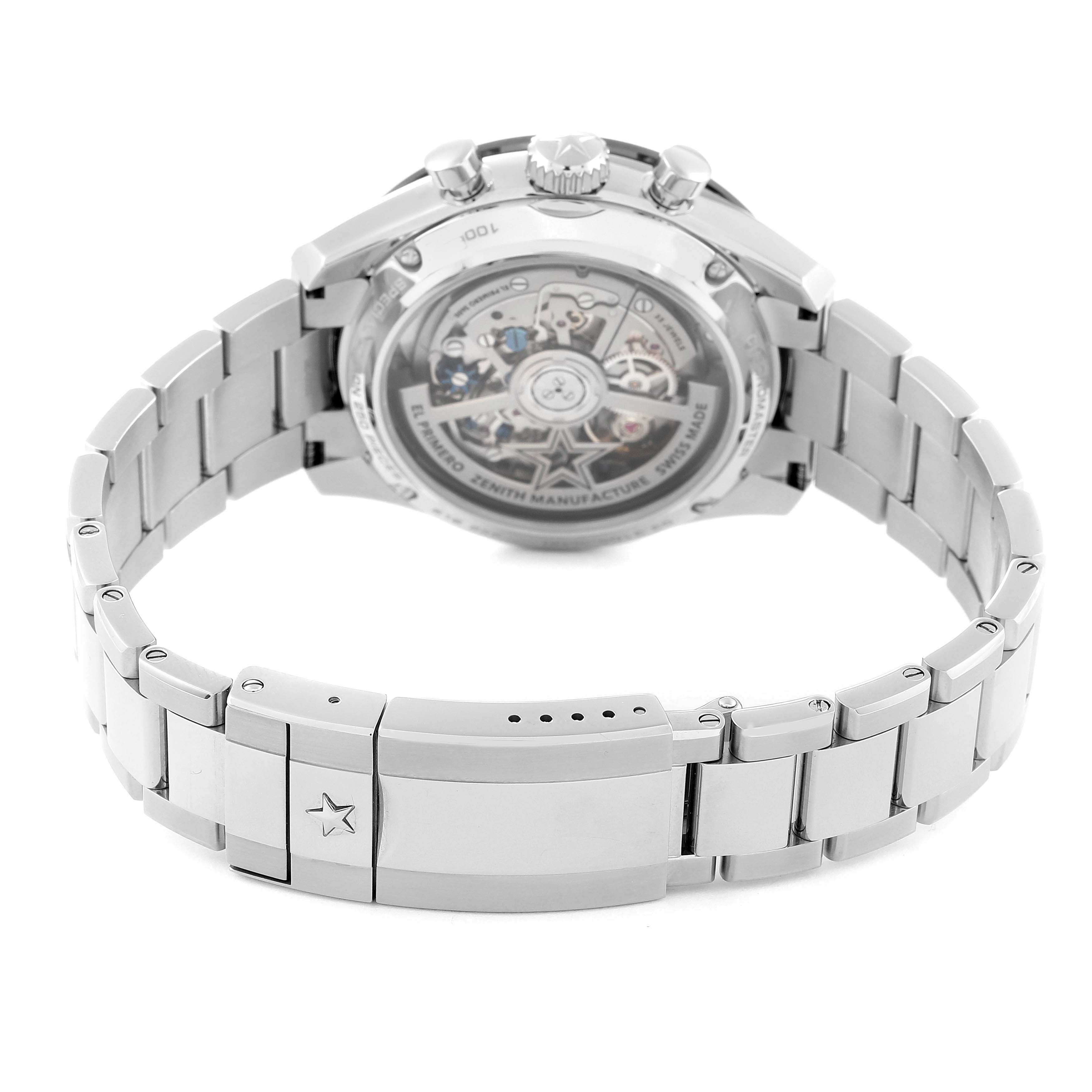 The image shows the back view of a Zenith El Primero watch, focusing on the stainless steel bracelet and the watch's transparent case back.