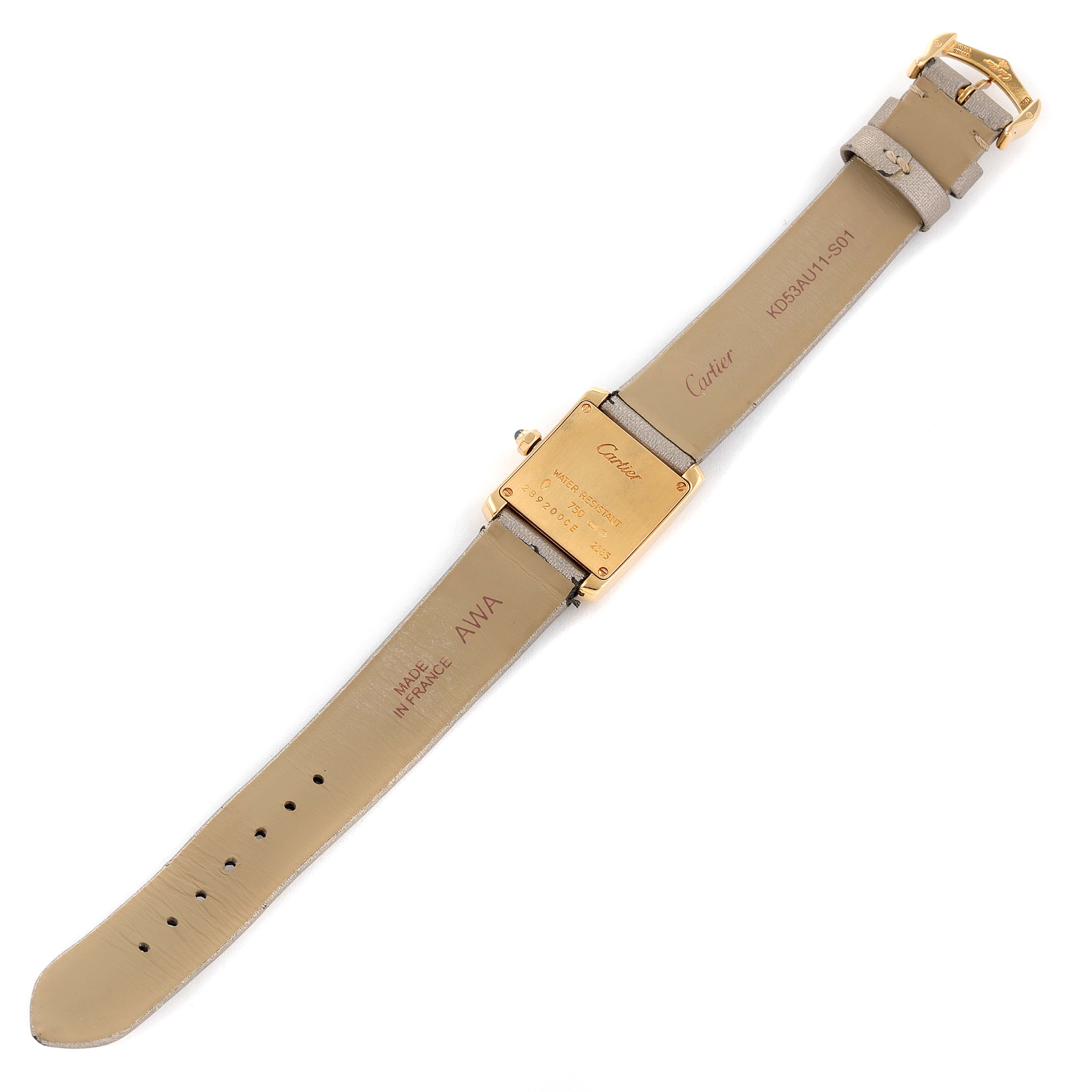 The image shows the back view of a Cartier Tank Francaise W5000256 Women
s Yellow Gold Silver Dial W5000256 Women
s Yellow Gold Silver Dial watch, highlighting the leather straps and the engraved case back.