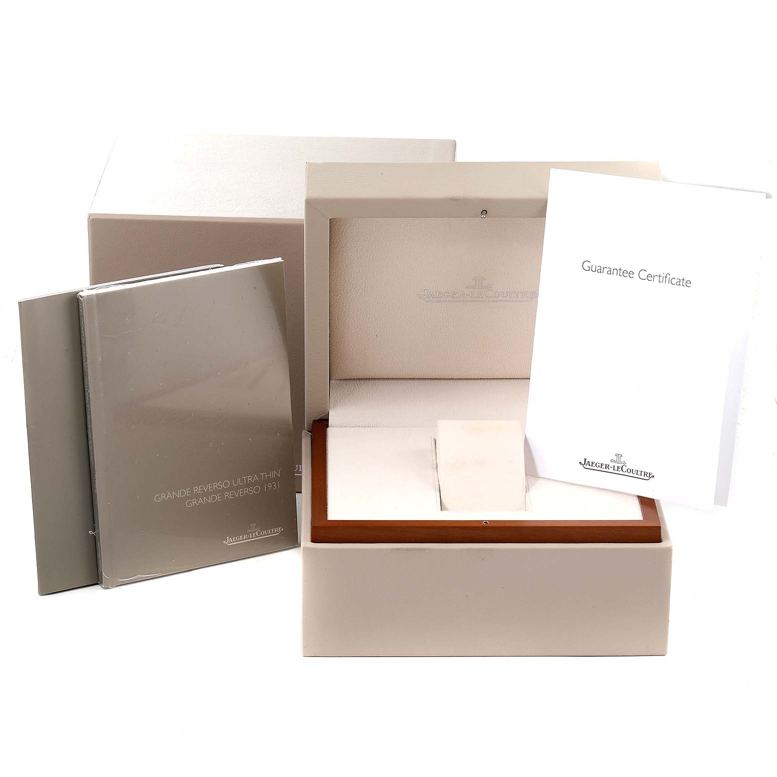 The image shows the packaging and accessories, including the box, manuals, and guarantee certificate, for the Jaeger-LeCoultre Reverso watch.