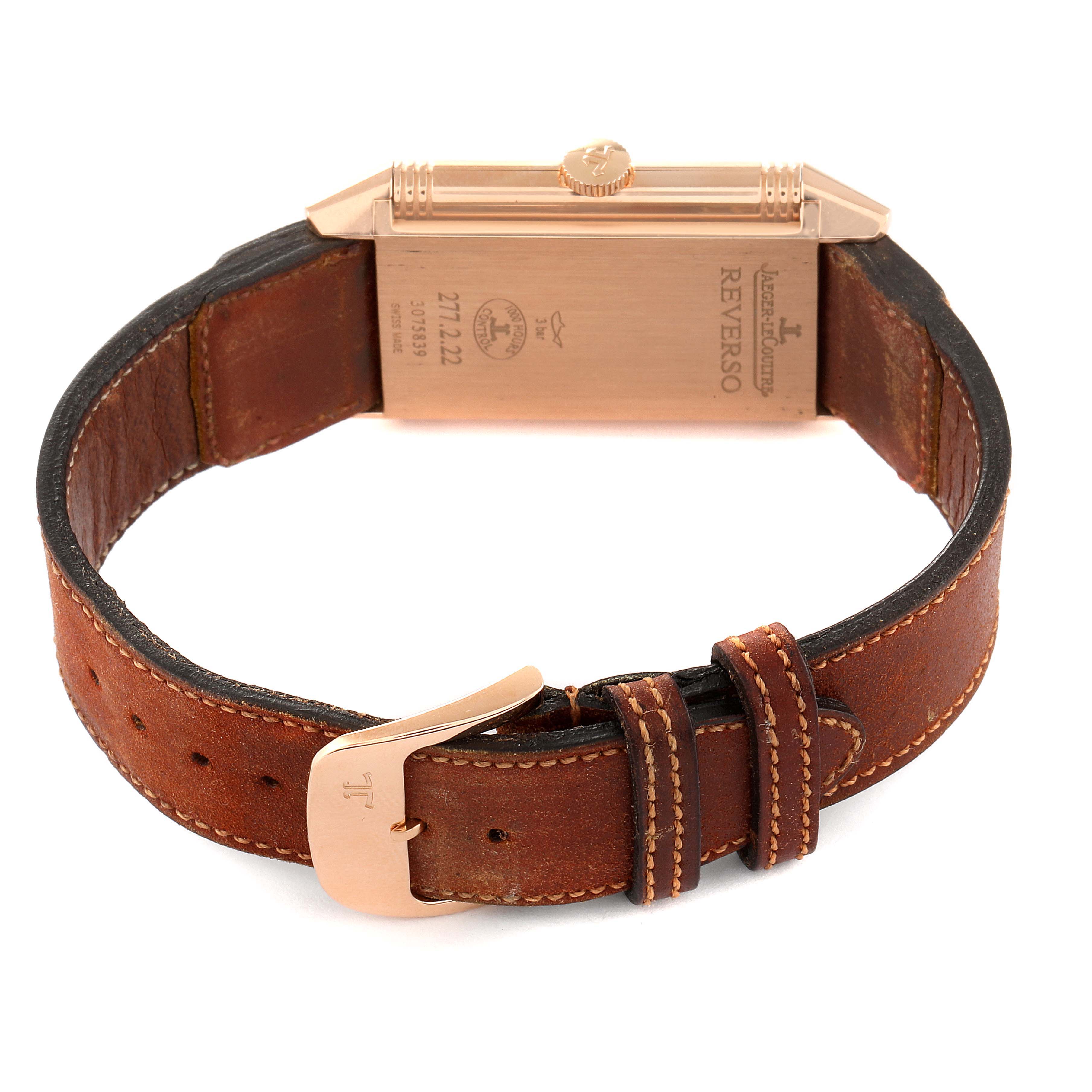 The image shows the back view of a Jaeger-LeCoultre Reverso watch with a leather strap and a rose-gold buckle.