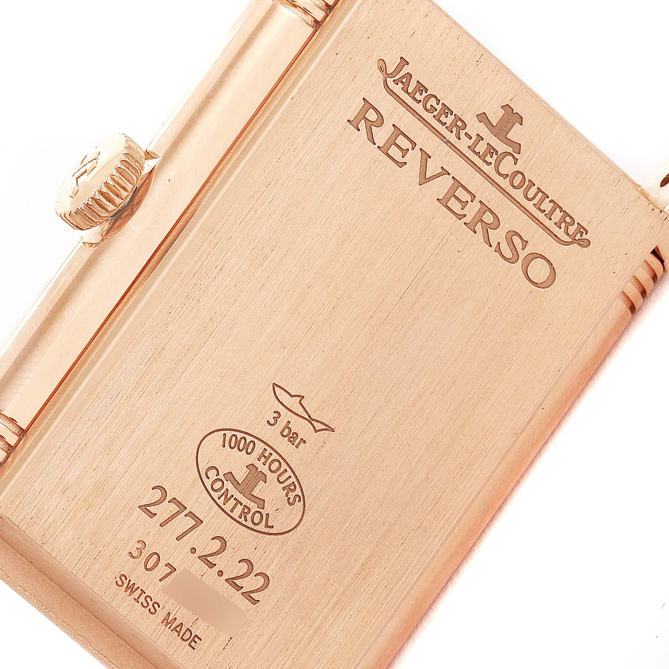 The image shows the side and back of a Jaeger-LeCoultre Reverso watch, featuring engravings and the crown.