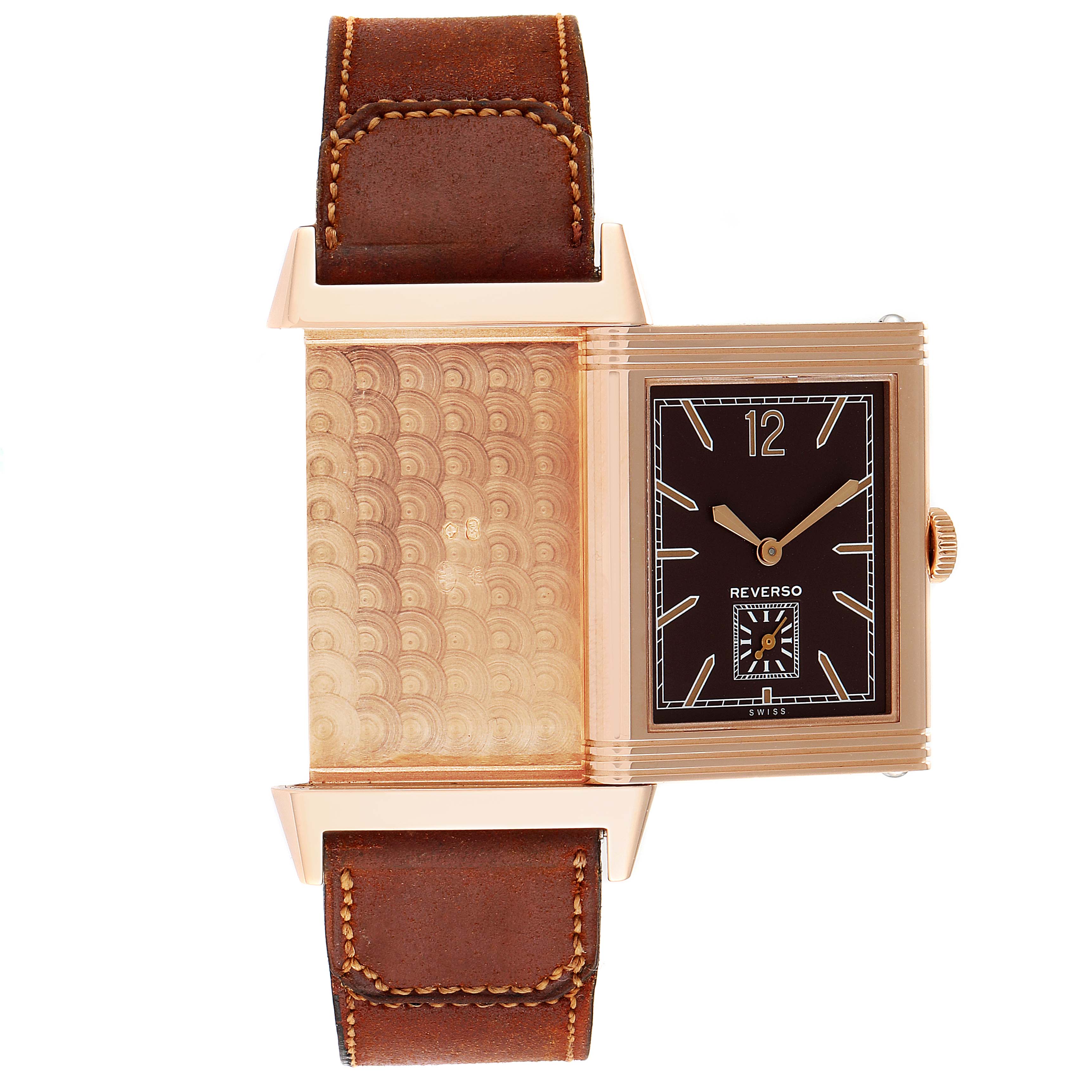 The image shows a Jaeger-LeCoultre Reverso watch with its reversible case partially opened, displaying the front dial and the engraved back.