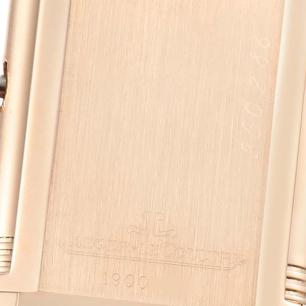 This close-up image shows the back casing of a Jaeger LeCoultre Reverso 250.2.86 Men's Rose Gold Black Dial 250.2.86 Men's Rose Gold Black Dial watch, highlighting the engraved branding and serial number.