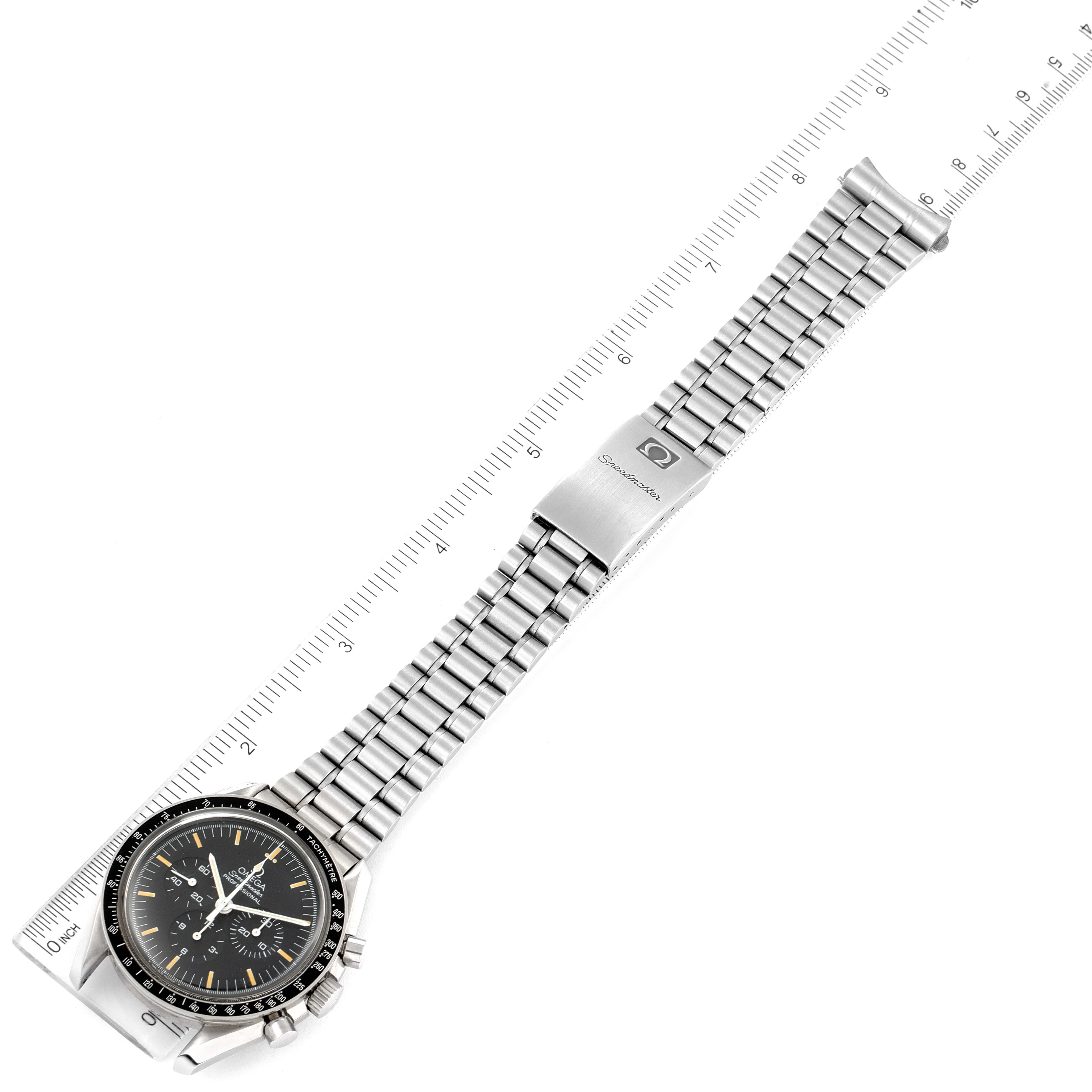 The image shows an Omega Speedmaster 3590.50.00 Men's Stainless Steel Black Dial 3590.50.00 Men's Stainless Steel Black Dial watch laid flat with a full view of the bracelet and clasp, next to a ruler for scale.