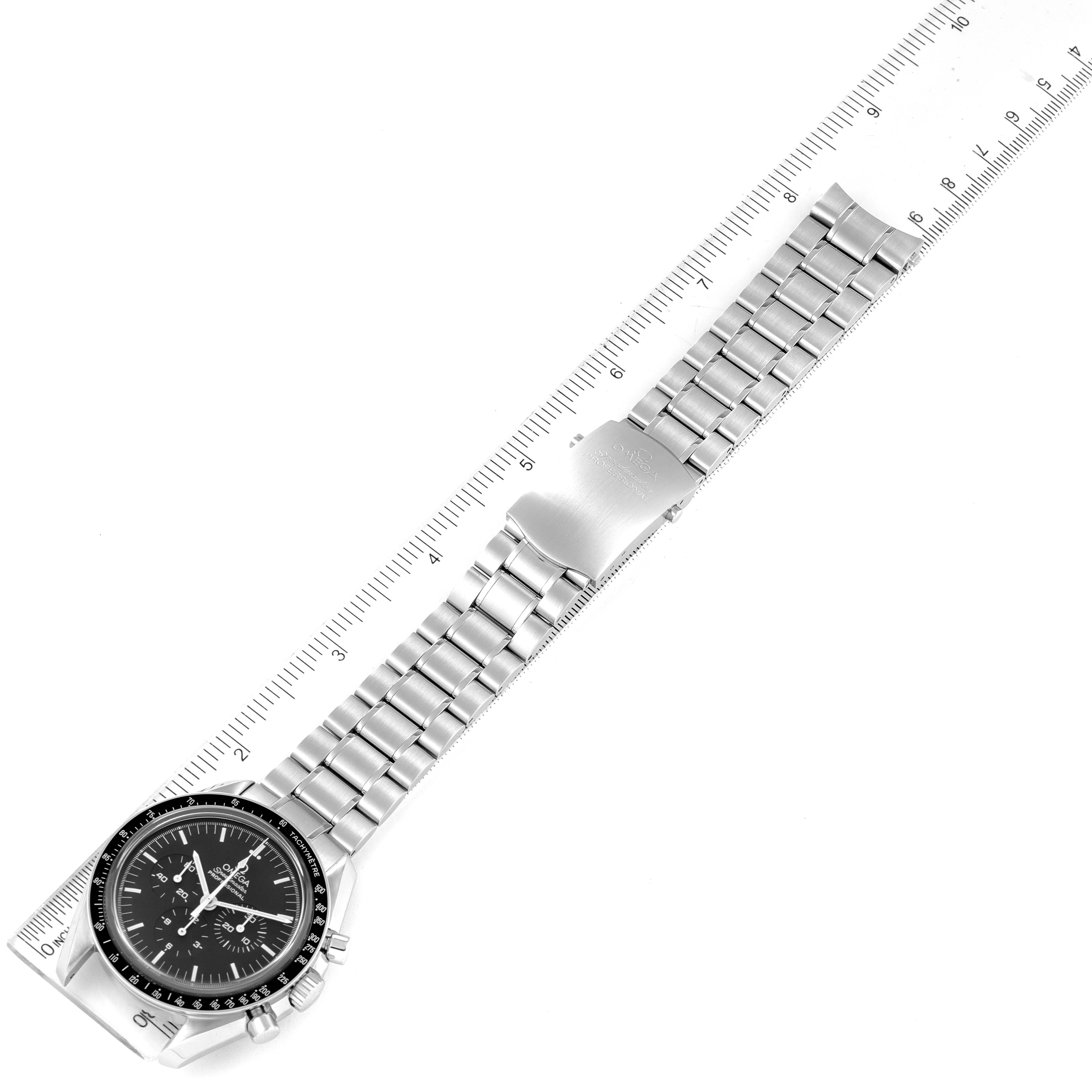 The Omega Speedmaster 3573.50.00 Men
s Stainless Steel Black Dial 3573.50.00 Men
s Stainless Steel Black Dial watch is shown from a top-down angle, displaying its face, bezel, bracelet, and clasp alongside a ruler for scale.