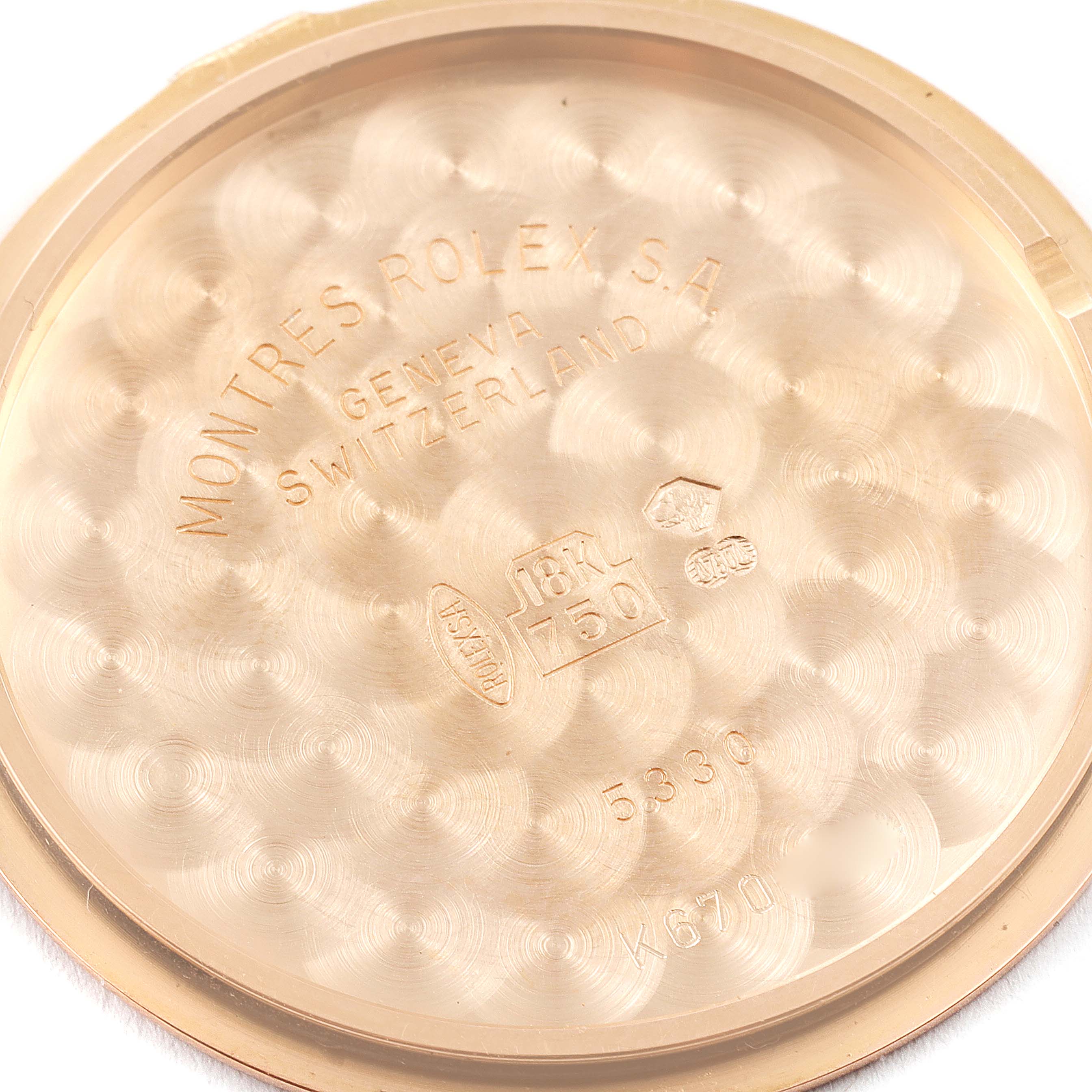 This image shows the inner side of the case back of a Rolex Cellini 5330 Men's Rose Gold Grey Dial 5330 Men's Rose Gold Grey Dial watch, detailing engravings and hallmarks.