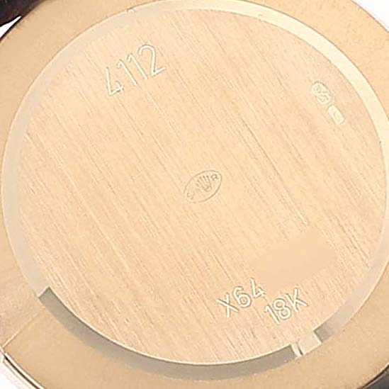 This image shows the back cover of a Rolex Cellini 4112 Men
s Yellow Gold Champagne Dial 4112 Men
s Yellow Gold Champagne Dial watch, displaying serial number information and indicating it is made from 18K gold.