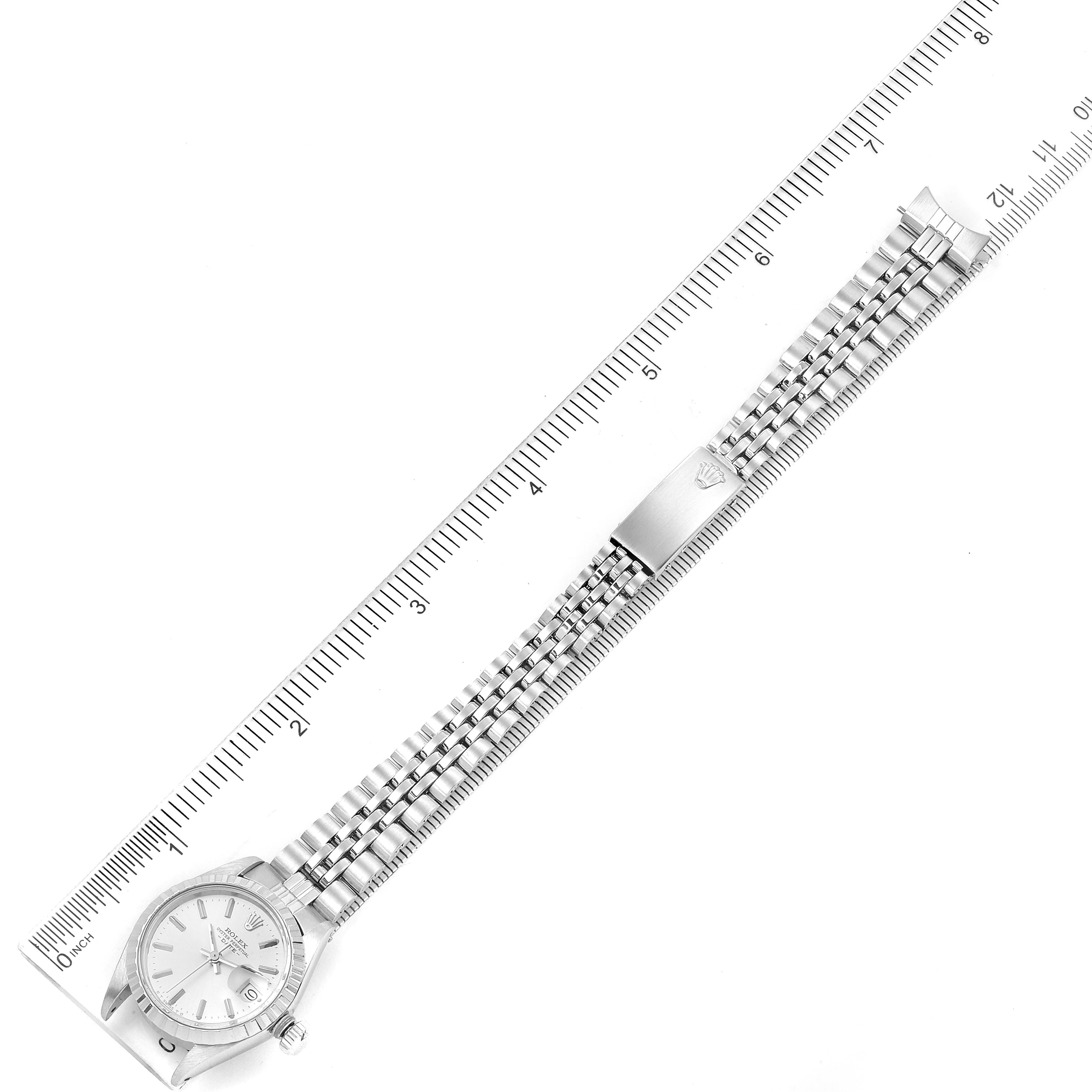 The image shows a top-down angle of a Rolex Date 6924 Women's Stainless Steel Silver Dial 6924 Women's Stainless Steel Silver Dial model watch, including its bracelet alongside a ruler for scale.