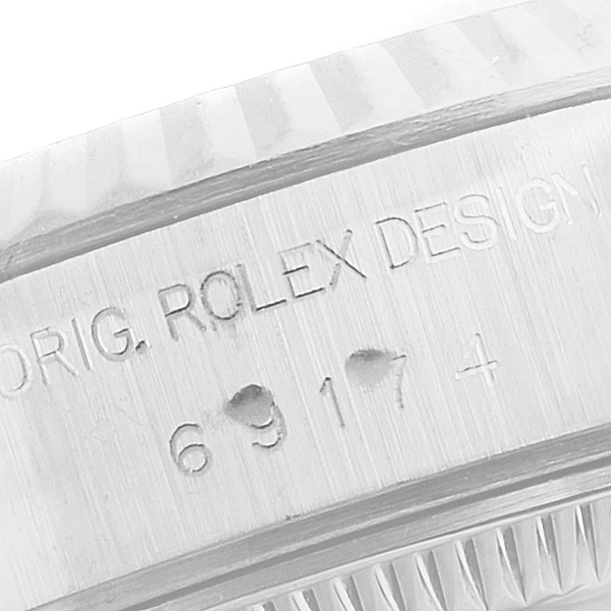 The image shows a close-up of the case side, focusing on the engraved serial number of a Rolex Datejust 69174 Women
s Stainless Steel Silver Dial 69174 Women
s Stainless Steel Silver Dial watch.