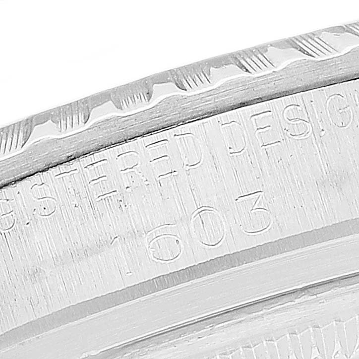 This close-up shows the engraved edge of the bezel and part of the casing of a Rolex Vintage Collection 1603 Men
s Stainless Steel Black Dial 1603 Men
s Stainless Steel Black Dial model watch.