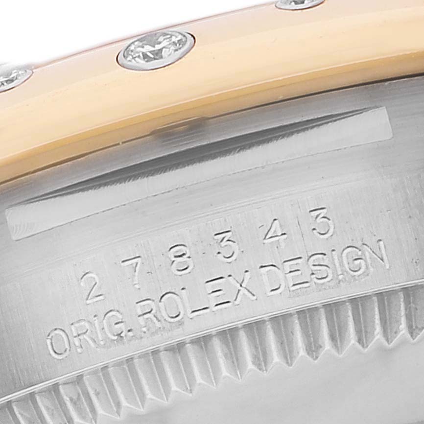 The image shows a close-up of the case back and bezel with diamonds of a Rolex Mid-Size 278343 Women's Steel and Gold (two tone) Grey Dial 278343 Women's Steel and Gold (two tone) Grey Dial model, highlighting the engraved serial number and "ORIG. ROLEX DESIGN."