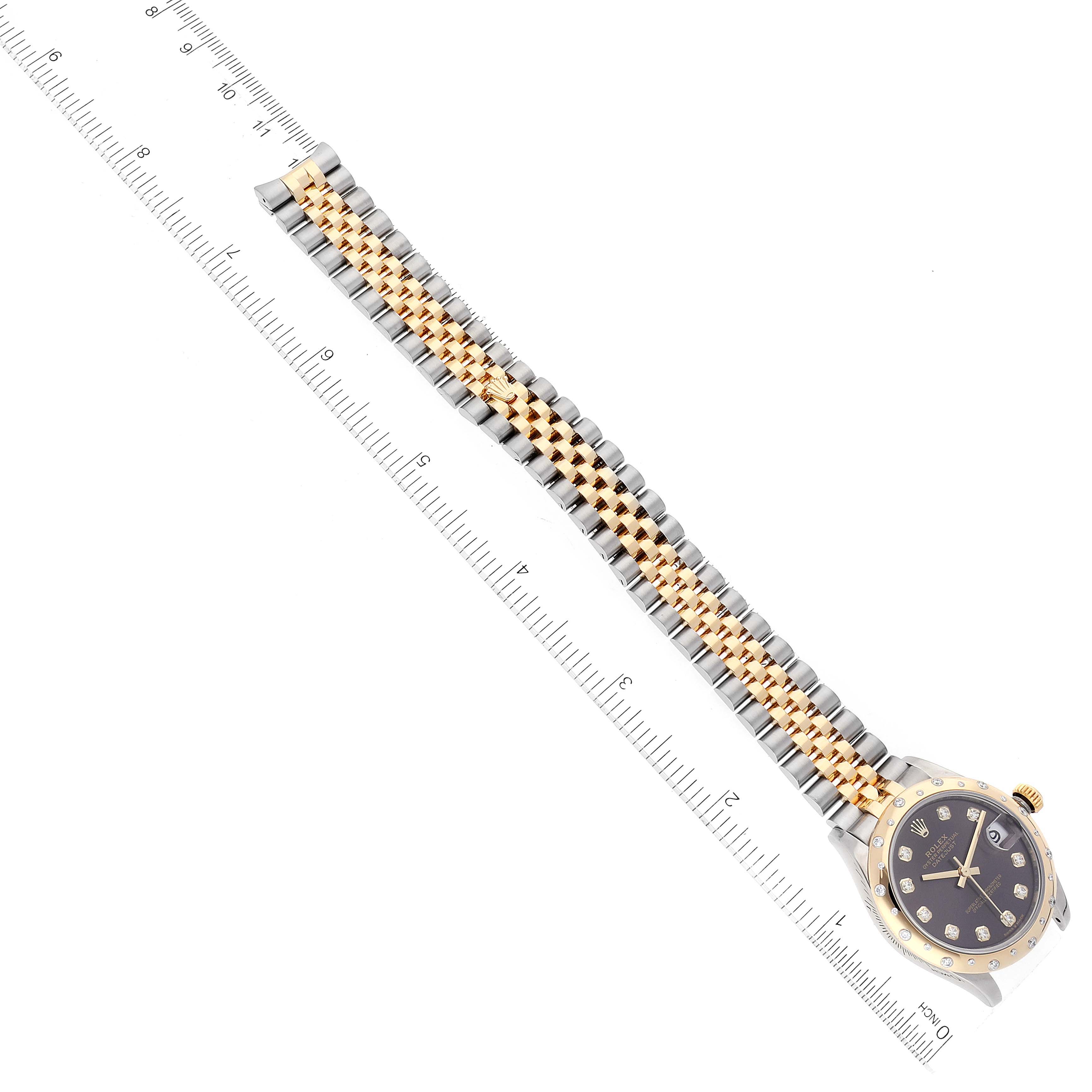 The image shows a Mid-Size Rolex watch at an angled view, displaying its face, crown, and two-tone bracelet alongside a ruler.