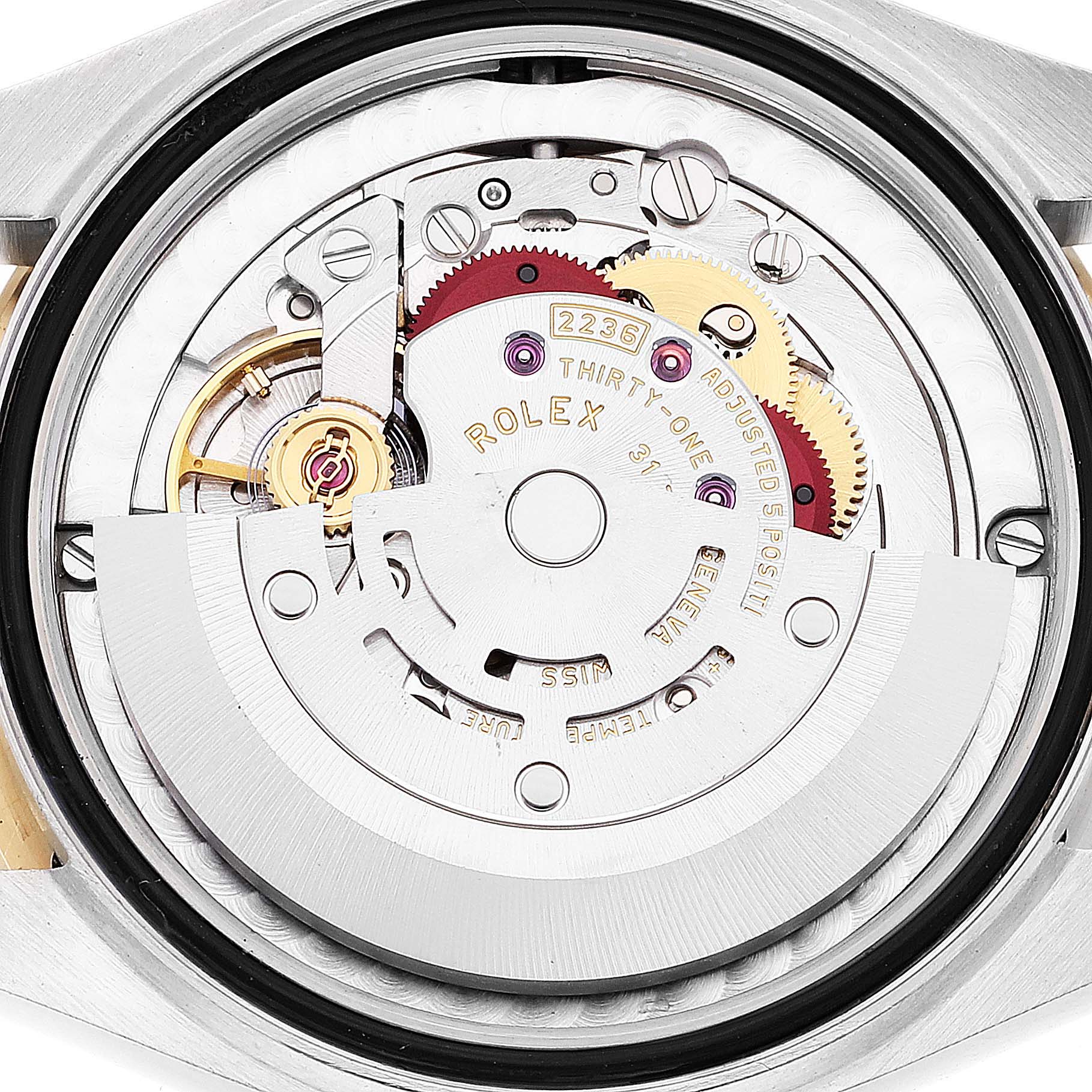 The image shows the internal mechanism of a mid-size Rolex watch from a back angle, highlighting the gears and movement components.