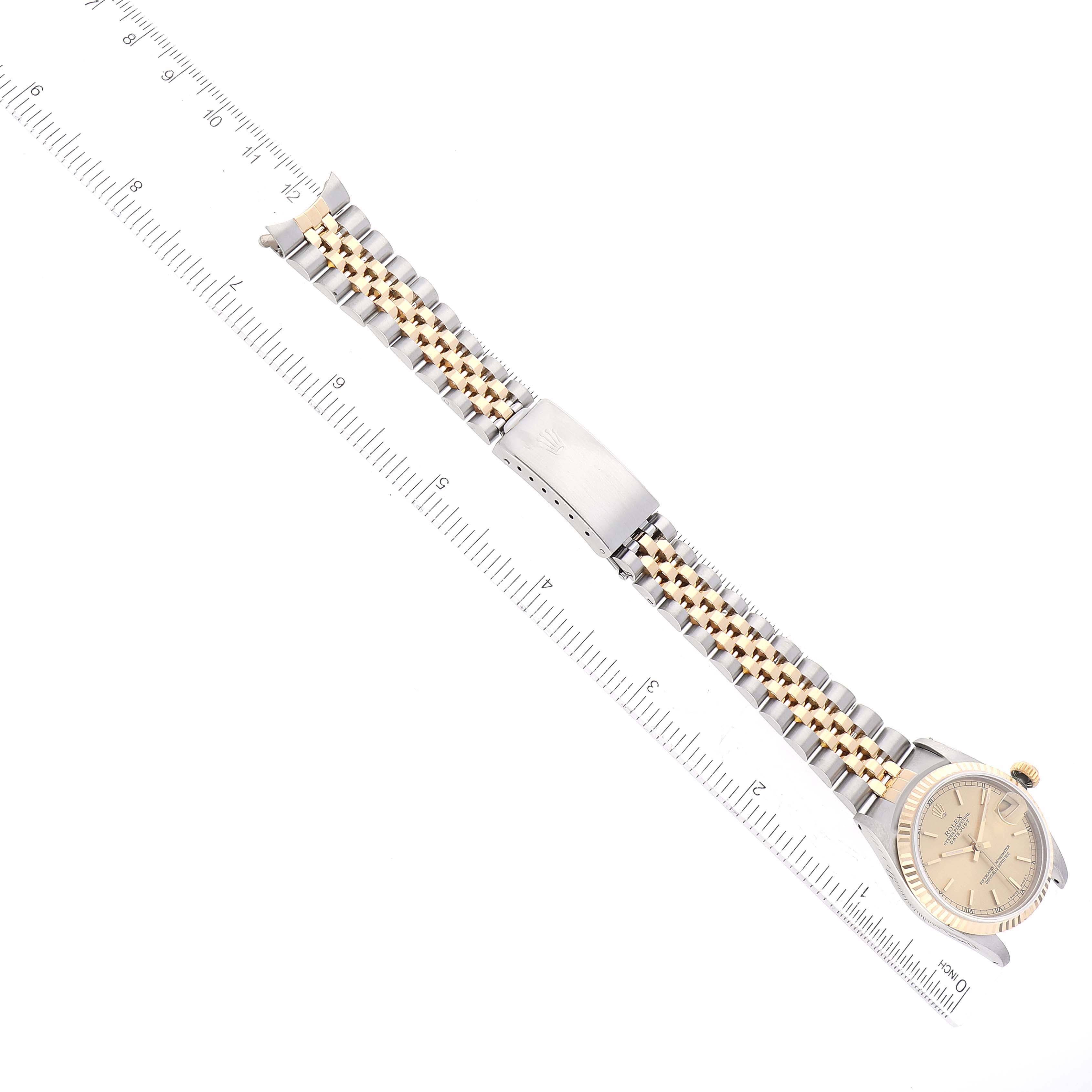 The image shows a Mid-Size Rolex watch laid flat, displaying the face, bracelet, and clasp along with a ruler for scale.