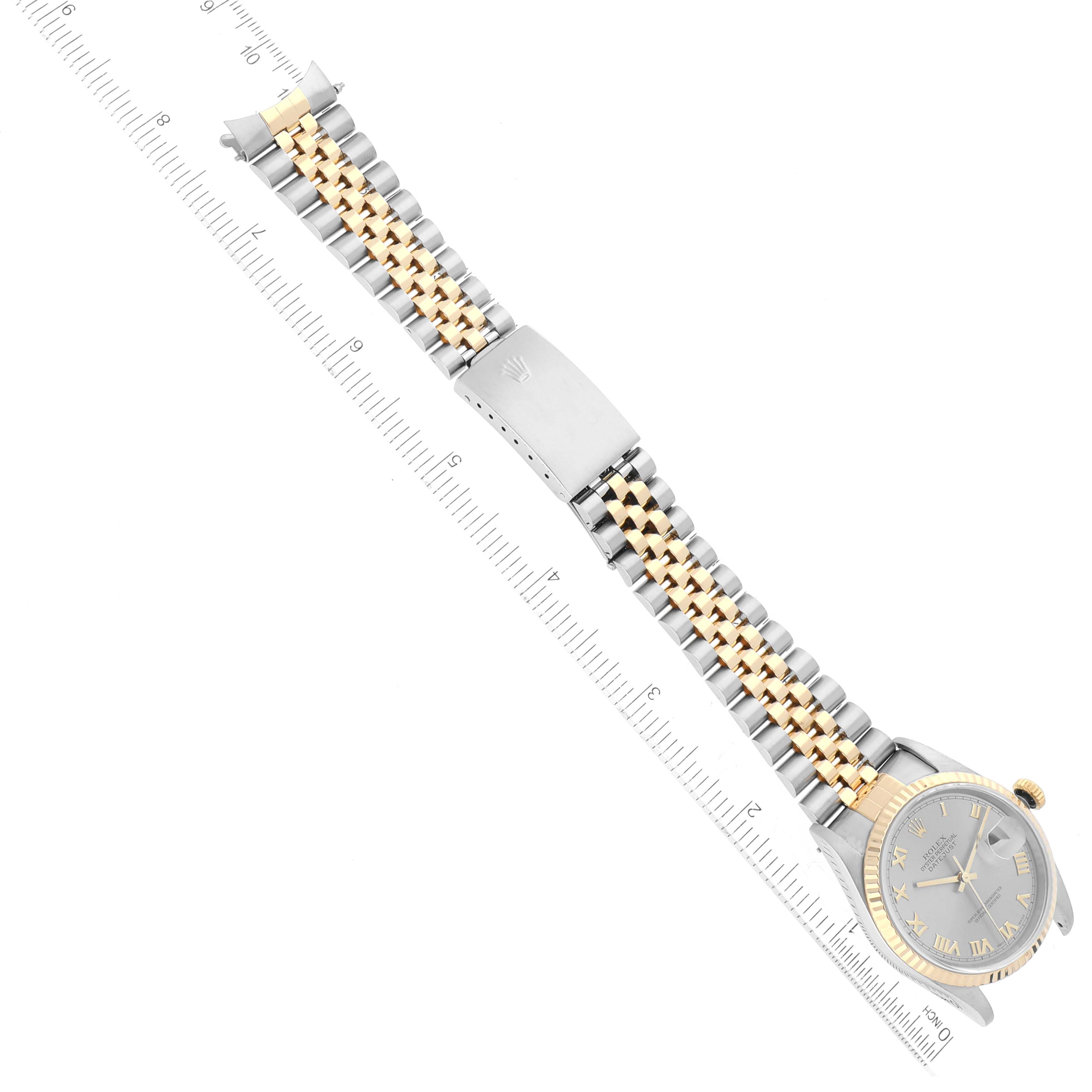 This image shows a top view of a Rolex Datejust 16233 Men's Steel and Gold (two tone) Grey Dial 16233 Men's Steel and Gold (two tone) Grey Dial watch, displaying its face, crown, two-tone bracelet, and clasp, alongside a ruler for scale.