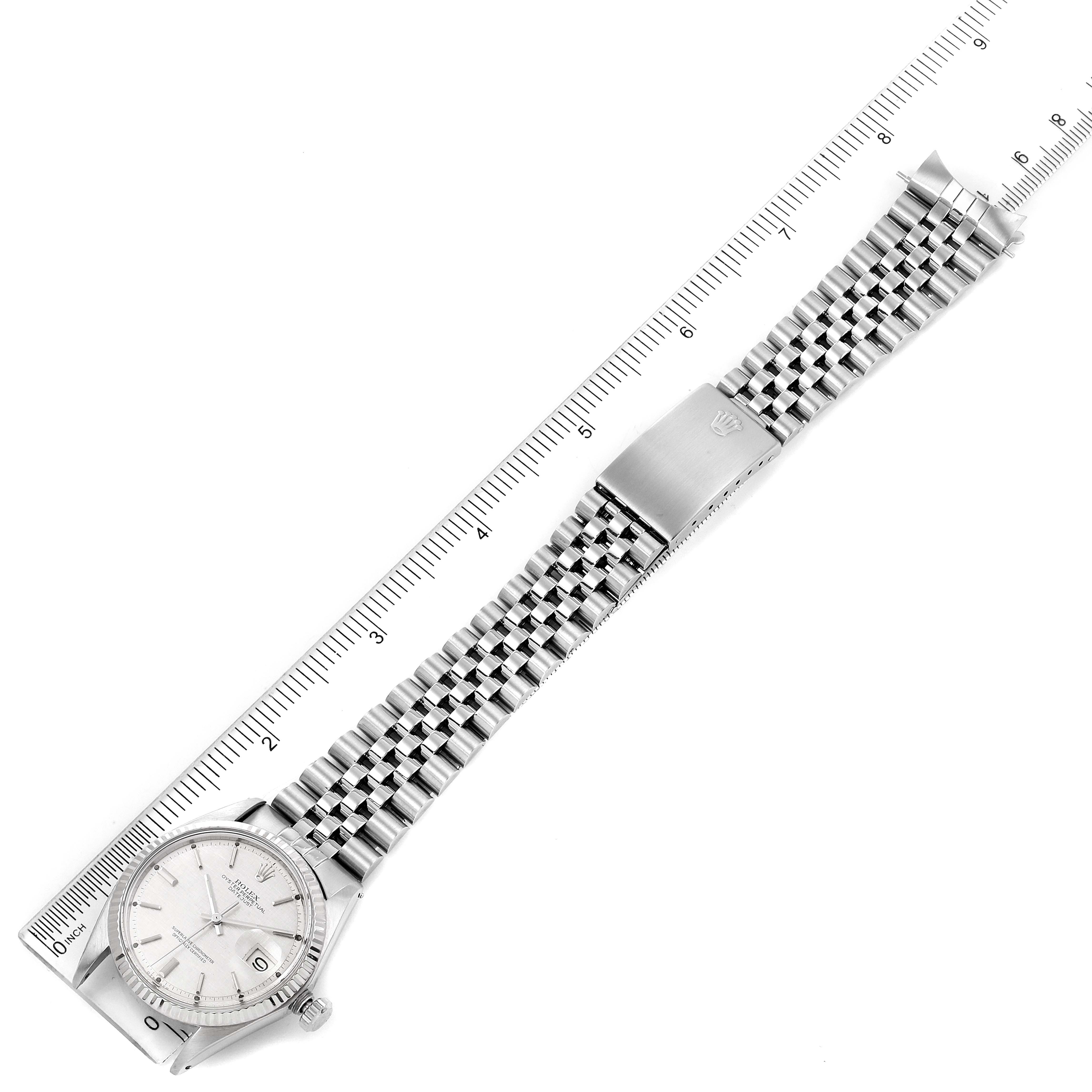 The Rolex Vintage Collection 1601 Men's Stainless Steel Silver Dial 1601 Men's Stainless Steel Silver Dial watch is shown flat with its face, bracelet, and clasp visible alongside a measuring ruler.