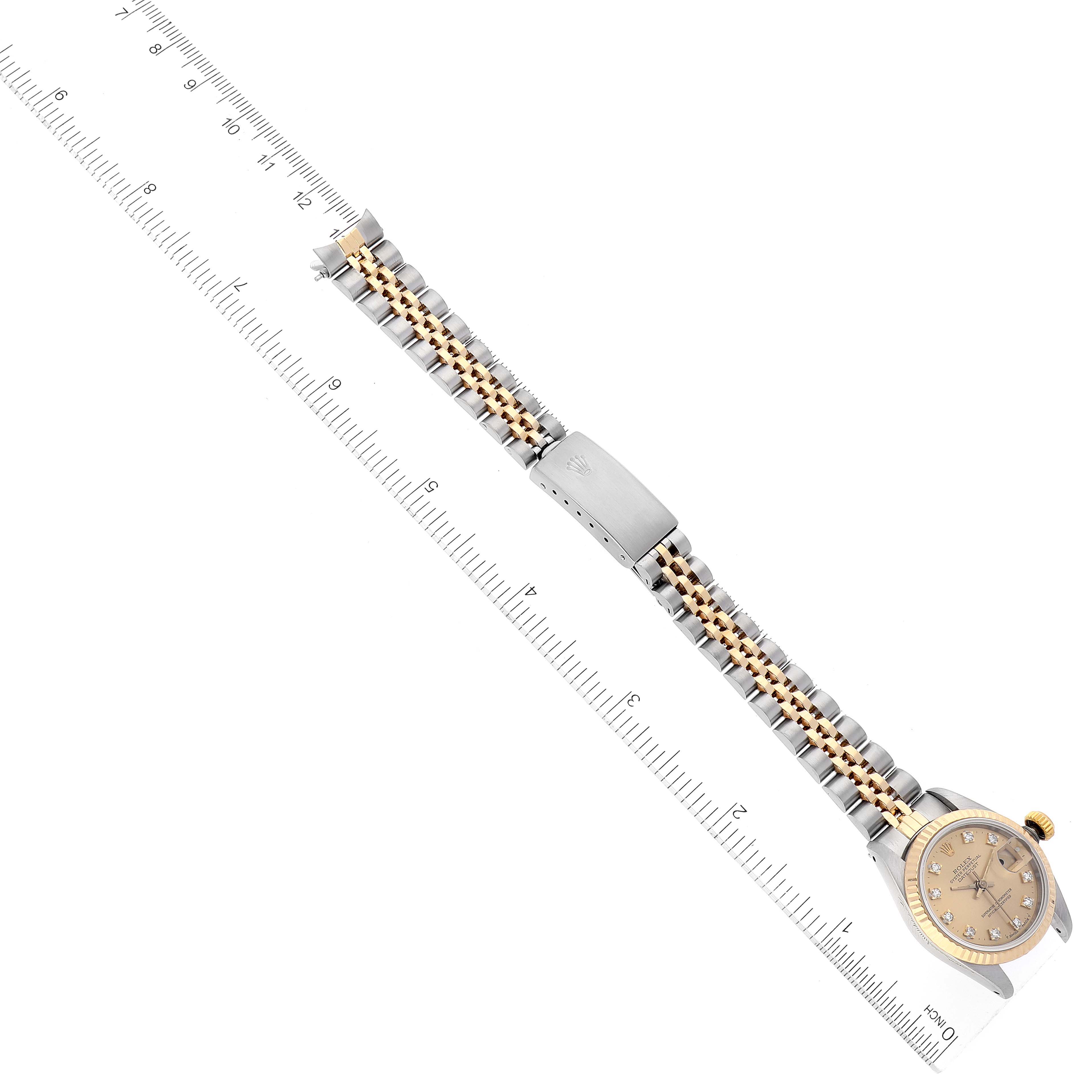 The image shows the Rolex Datejust 69173 Women's Steel and Gold (two tone) Champagne Dial 69173 Women's Steel and Gold (two tone) Champagne Dial watch laid flat, showcasing its band and clasp alongside a ruler for scale.