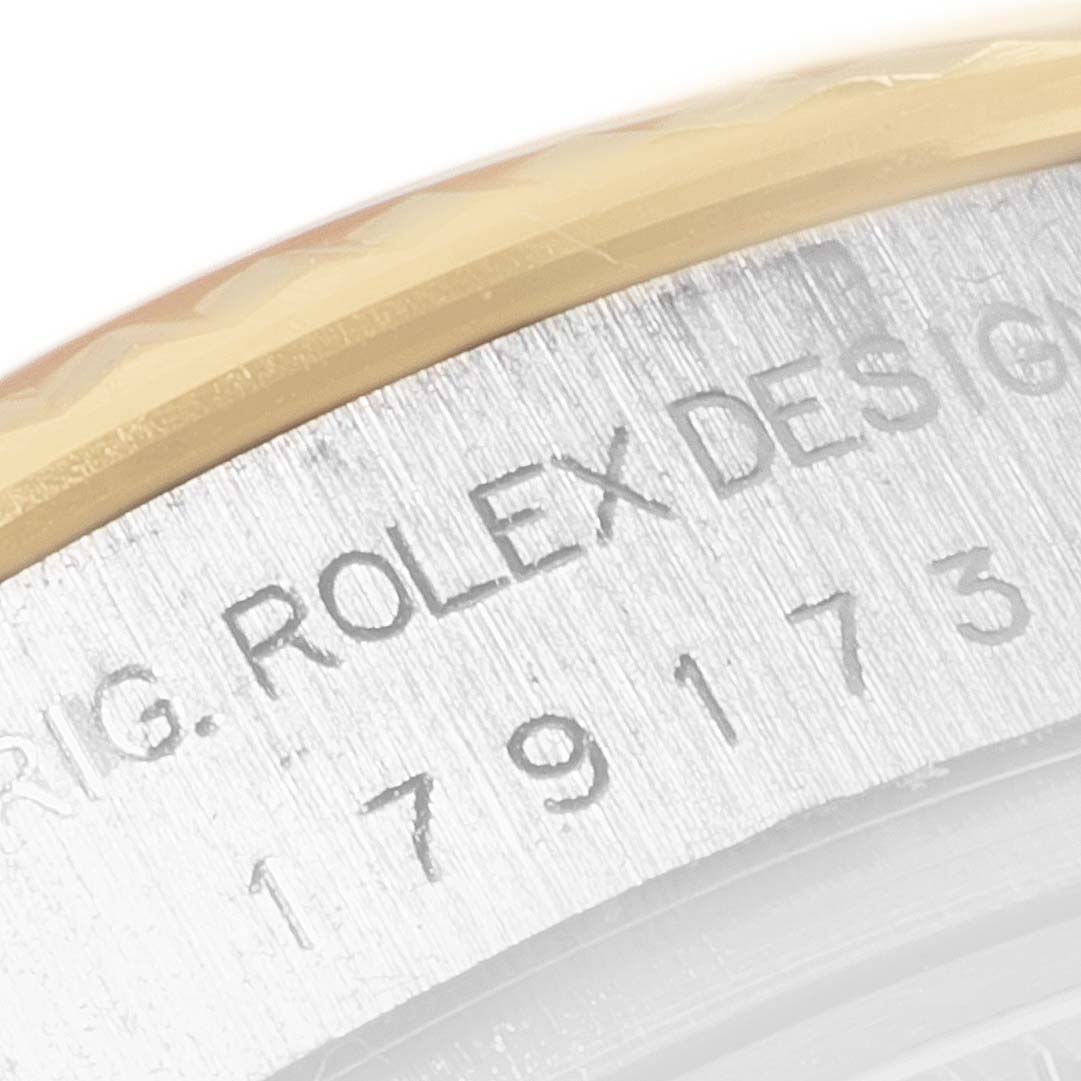 The image shows a close-up of the engraved details on the casing of a Rolex Datejust 179173 Women's Steel and Gold (two tone) Pink Dial 179173 Women's Steel and Gold (two tone) Pink Dial watch.