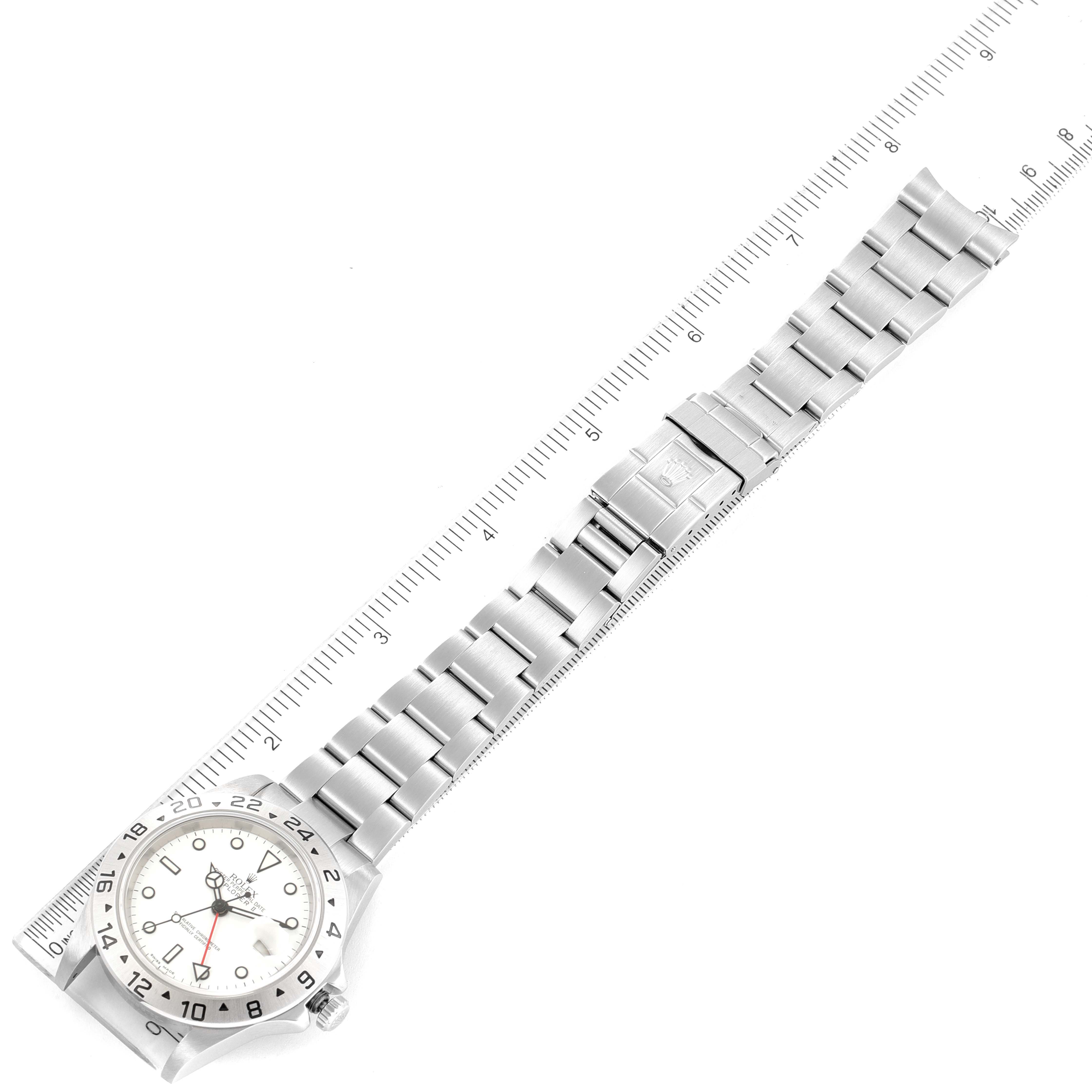 The image shows a top-down view of a Rolex Explorer 16570 Men's Stainless Steel White Dial 16570 Men's Stainless Steel White Dial watch with a silver metal bracelet placed against a ruler for measurement.