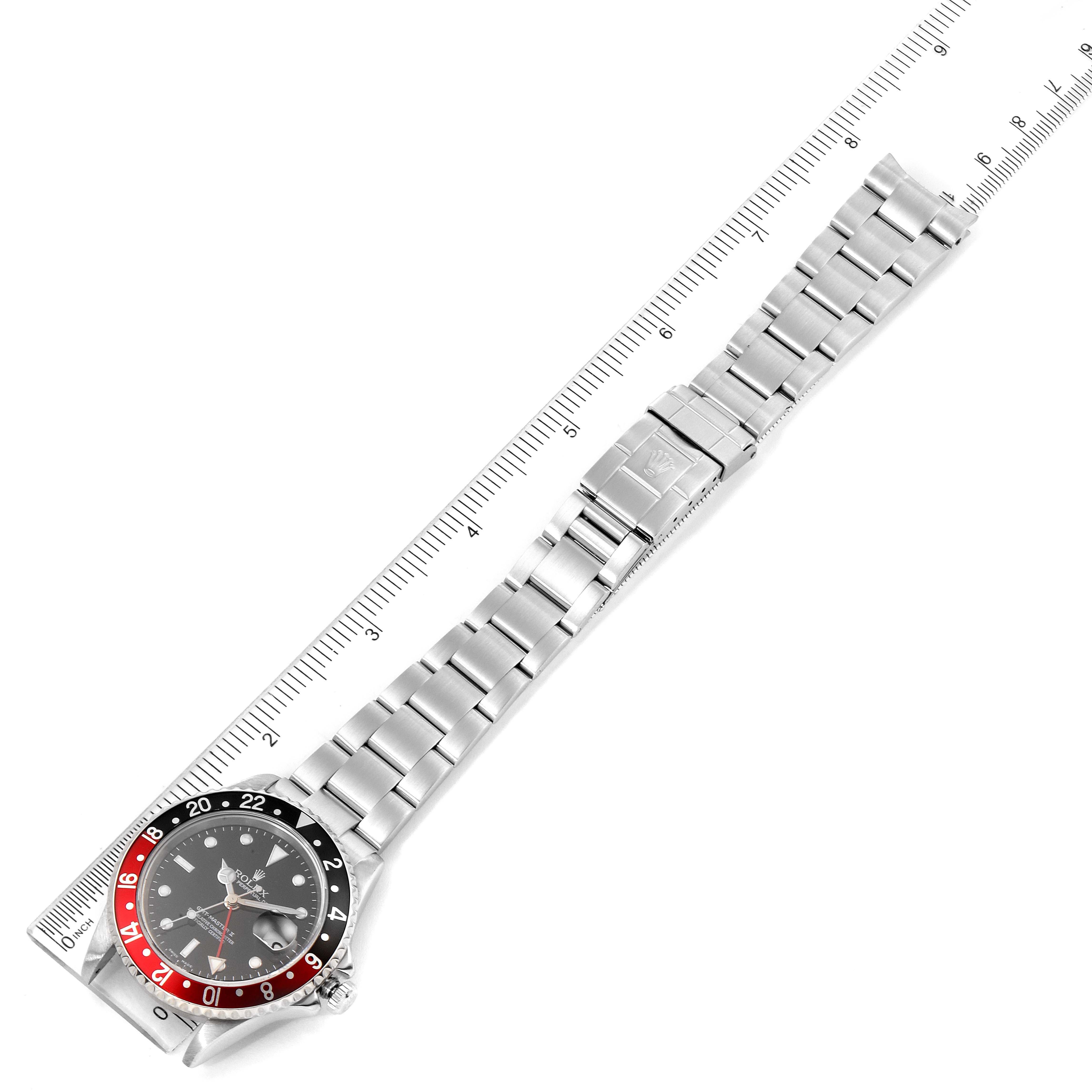 The image shows a top-down view of a Rolex GMT-Master 16710 Men's Stainless Steel Black Dial 16710 Men's Stainless Steel Black Dial watch and its metal bracelet placed alongside a ruler for scale.