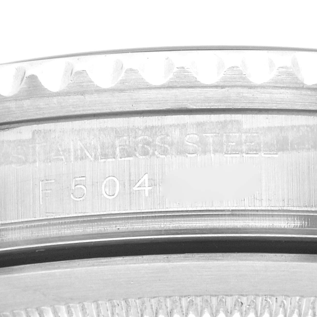 The image shows a close-up of the edge of a Rolex GMT-Master 16710 Men
s Stainless Steel Black Dial 16710 Men
s Stainless Steel Black Dial model watch, focusing on the serial number and "STAINLESS STEEL" engraving.