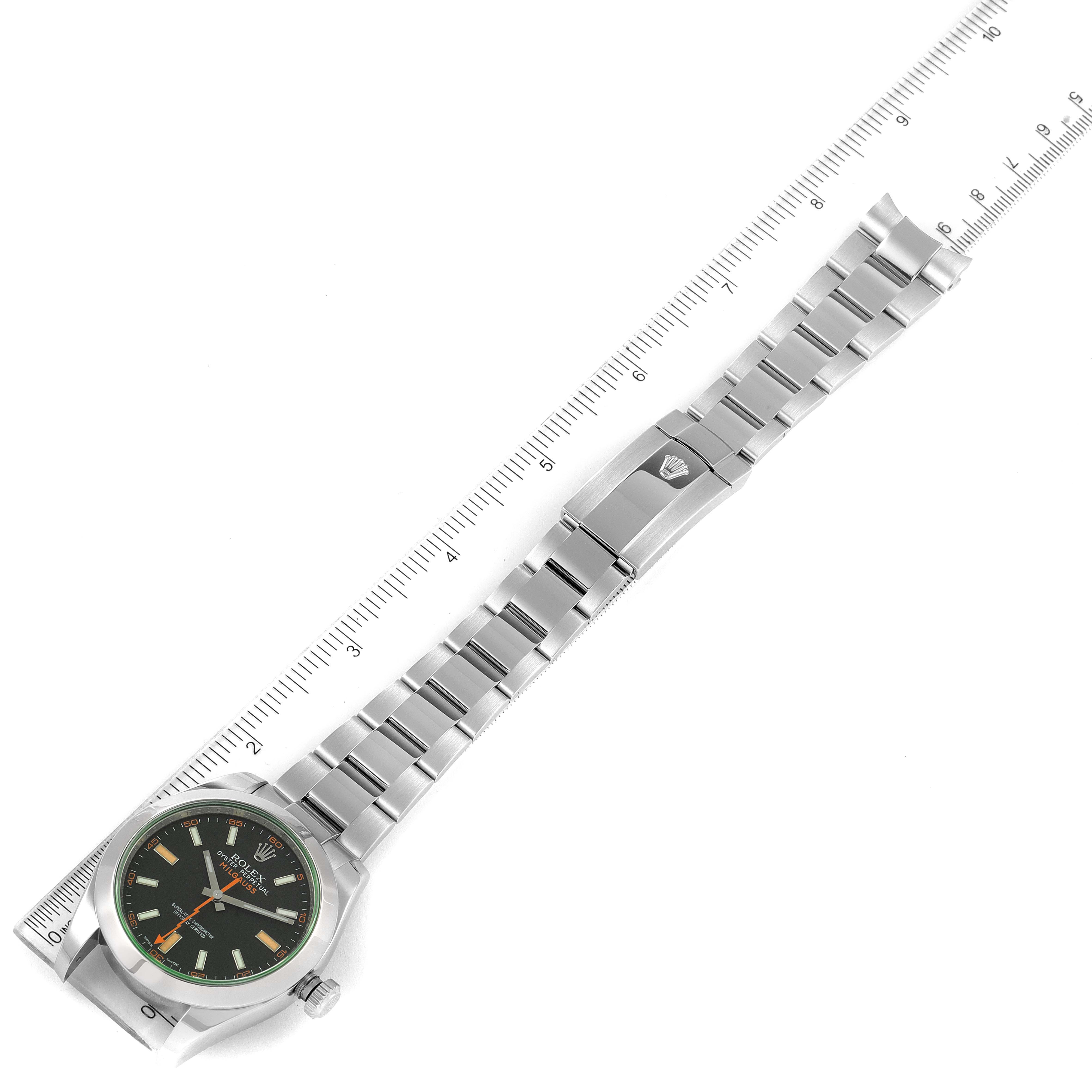 The Rolex Milgauss 116400V Men's Stainless Steel Black Dial 116400V Men's Stainless Steel Black Dial watch is shown from a top-down angle, displaying the face, band, and clasp, alongside a measuring ruler.