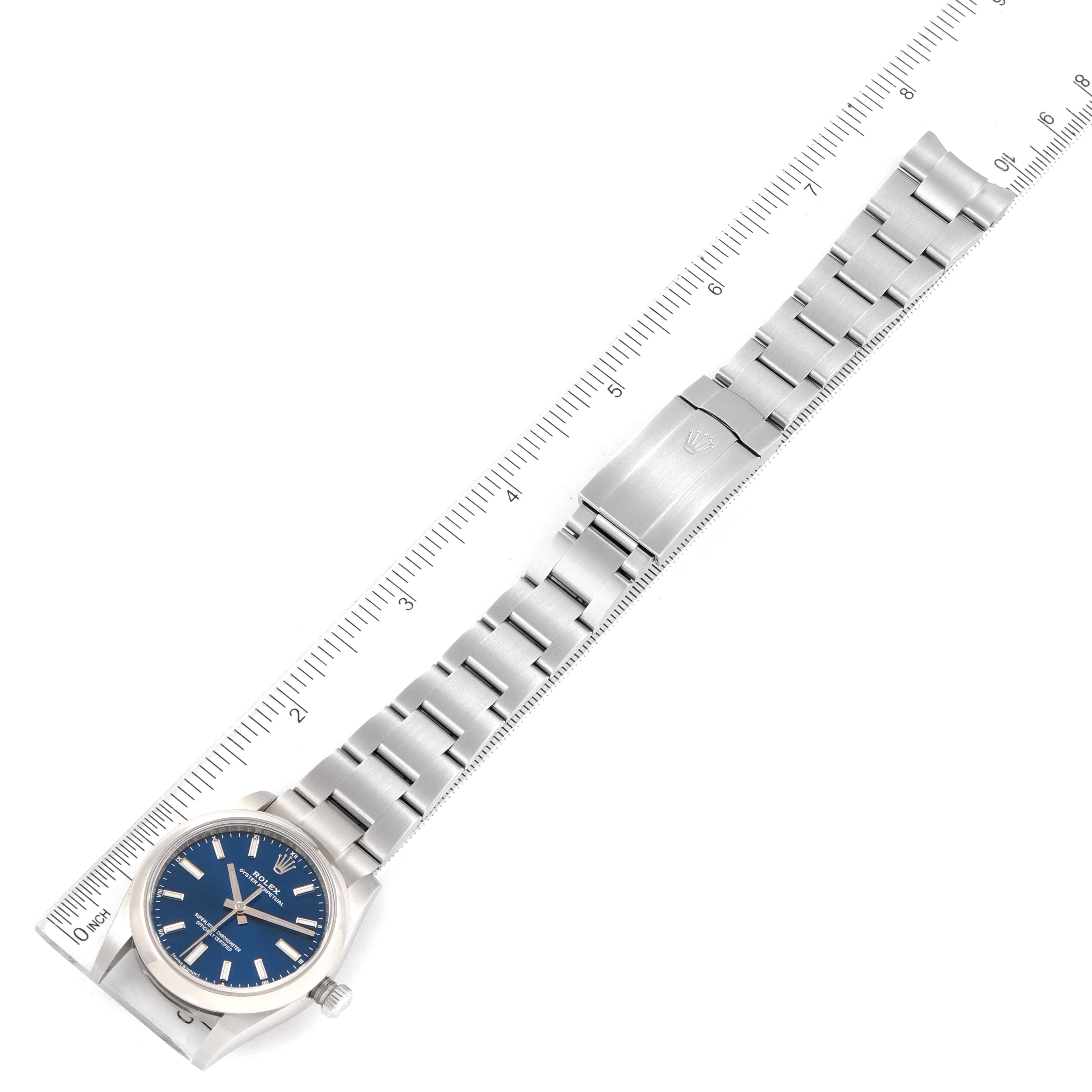 The Rolex Oyster Perpetual 124200 Men's Stainless Steel Blue Dial 124200 Men's Stainless Steel Blue Dial watch is shown laid flat with a blue dial, full bracelet, and a ruler for scale.