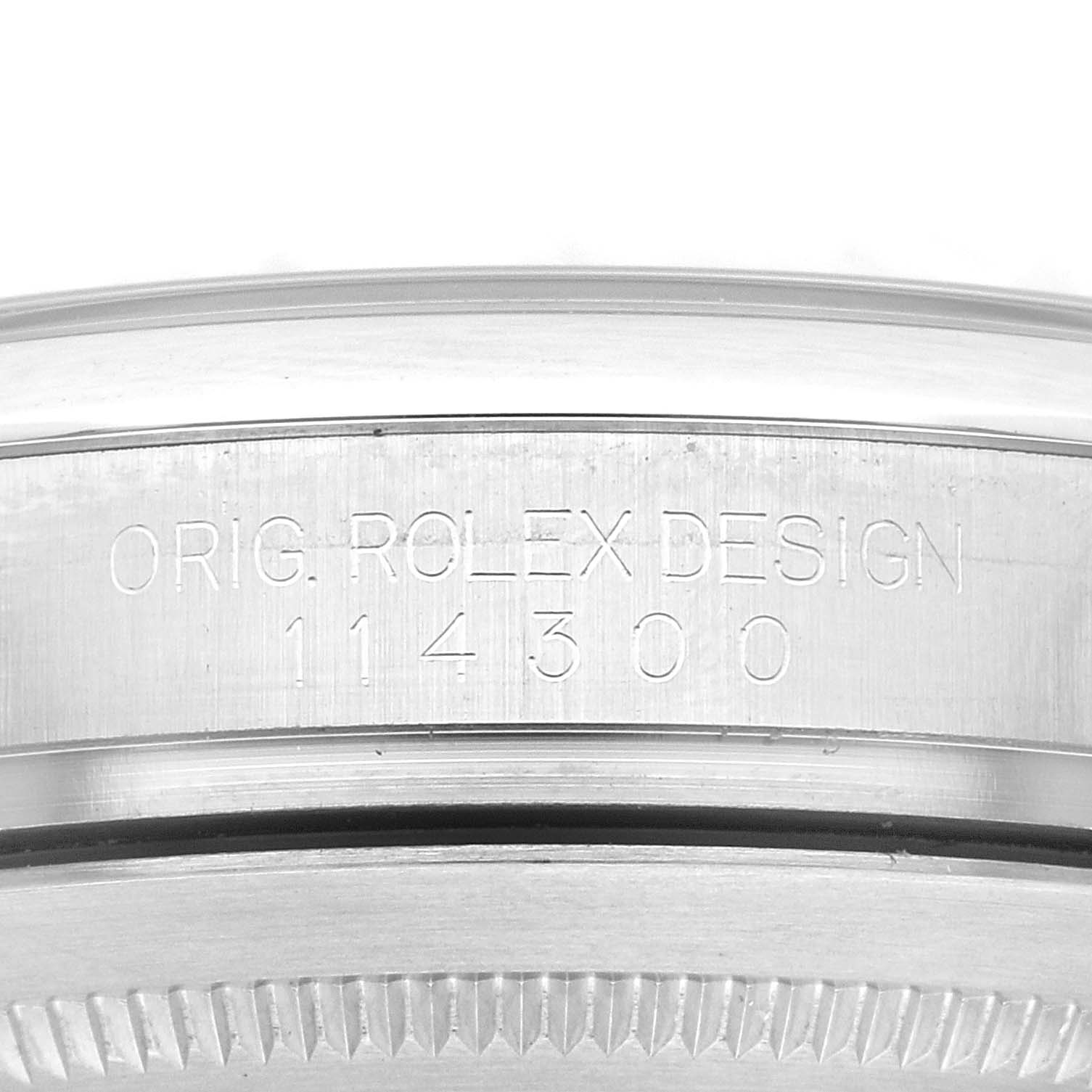 This image shows a close-up of the case side of a Rolex Oyster Perpetual 114300 Men
s Stainless Steel Black Dial 114300 Men
s Stainless Steel Black Dial model, displaying its engraving and reference number 114300.