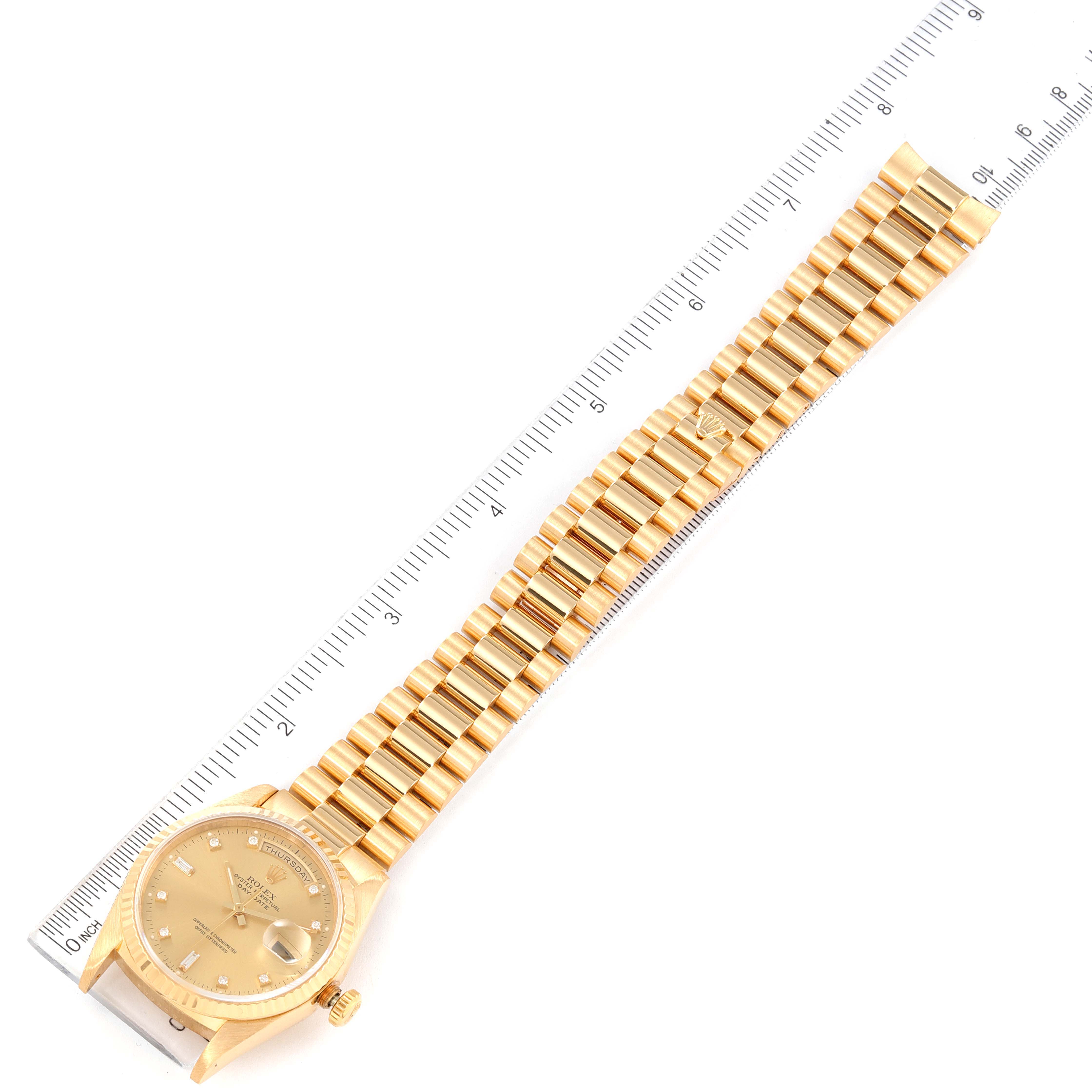The image shows a Rolex President 18238 Men
s Yellow Gold Champagne Dial 18238 Men
s Yellow Gold Champagne Dial model watch, including the full gold bracelet and face, laid next to a ruler for measurement.