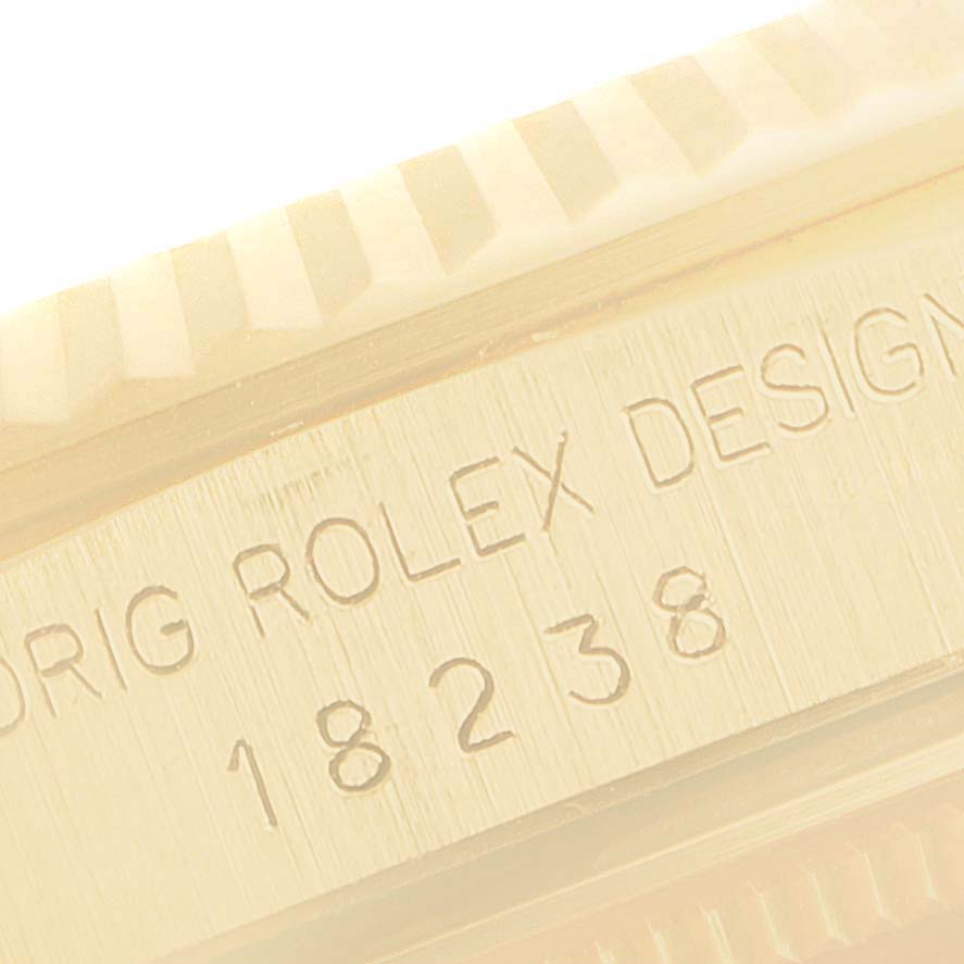 This close-up image shows the engraved model number and part of the fluted bezel on a Rolex President 18238 Men's Yellow Gold Champagne Dial 18238 Men's Yellow Gold Champagne Dial watch.